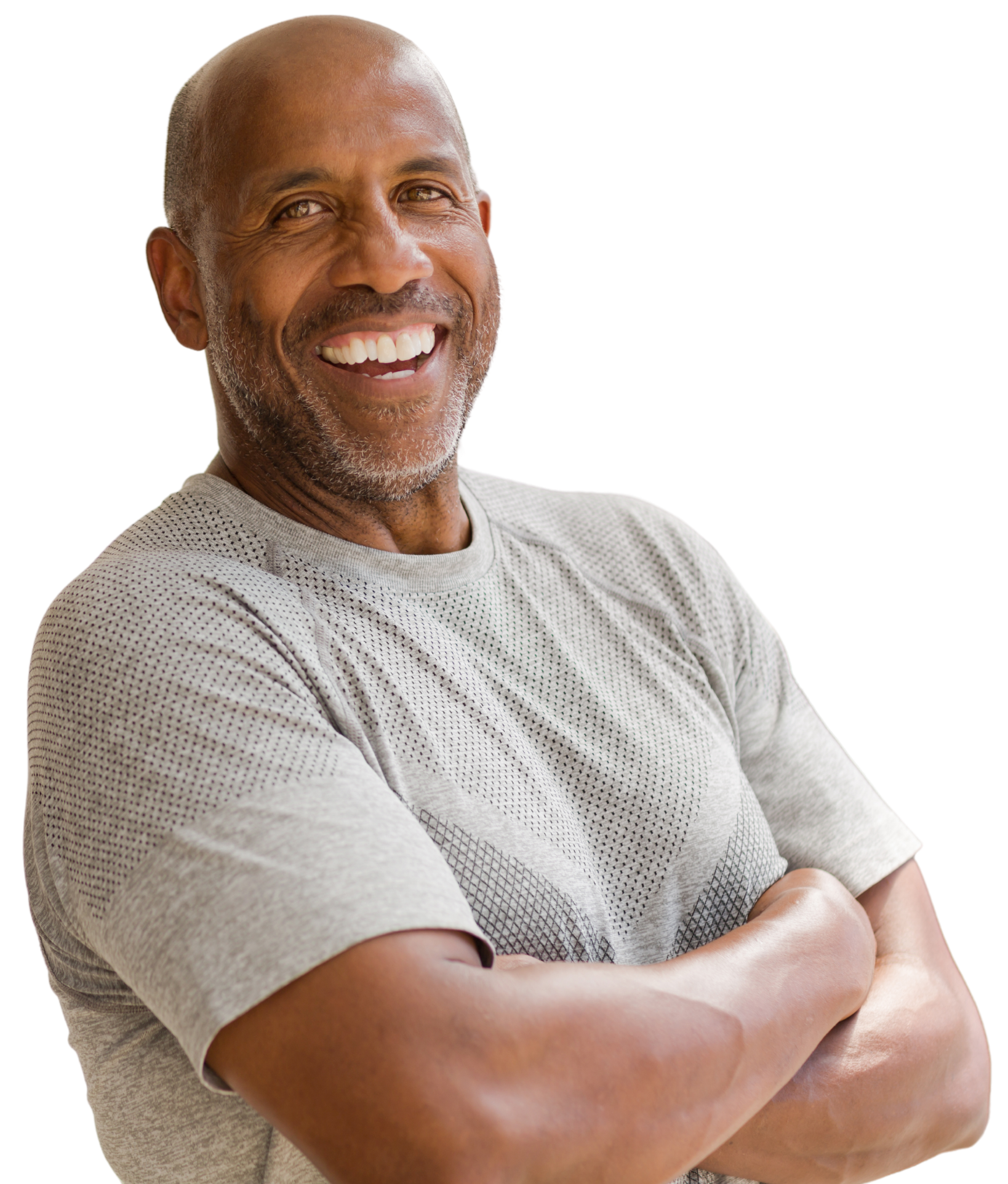 A man in a grey shirt is smiling with his arms crossed