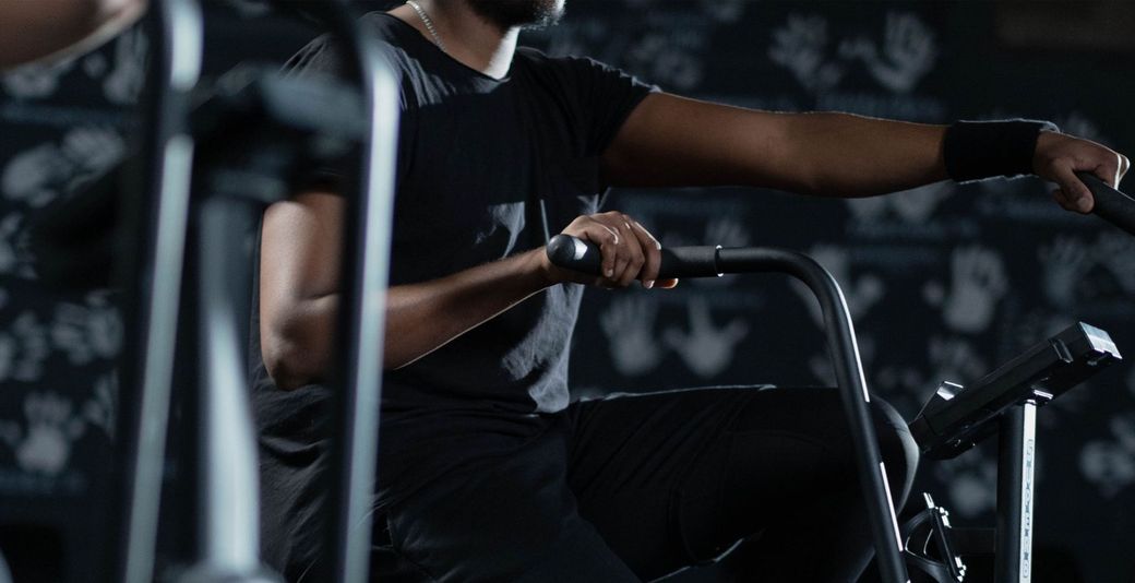 A man is riding an exercise bike in a gym.