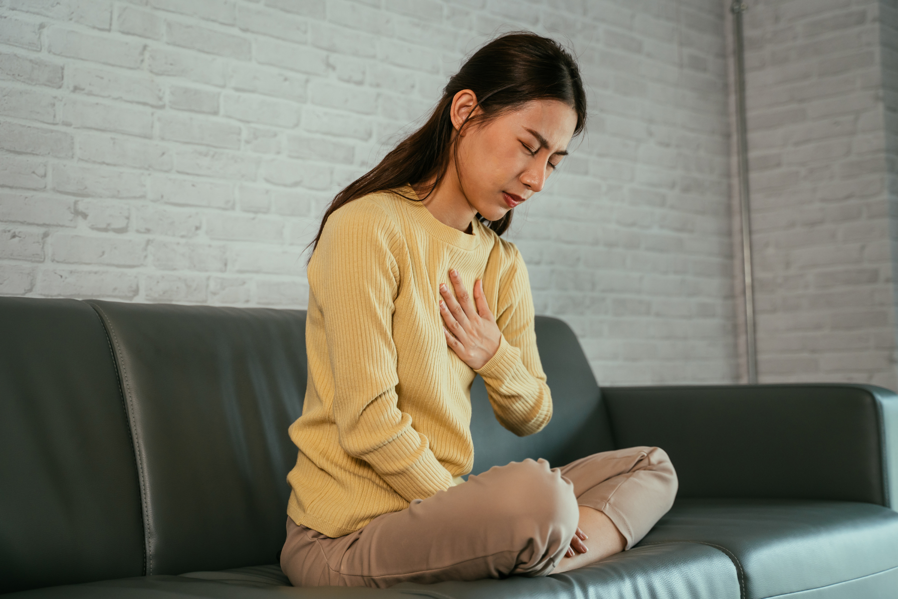 Woman experiencing chest pain and shortness of breath, which are common symptoms of Mixed Connective Tissue Disease