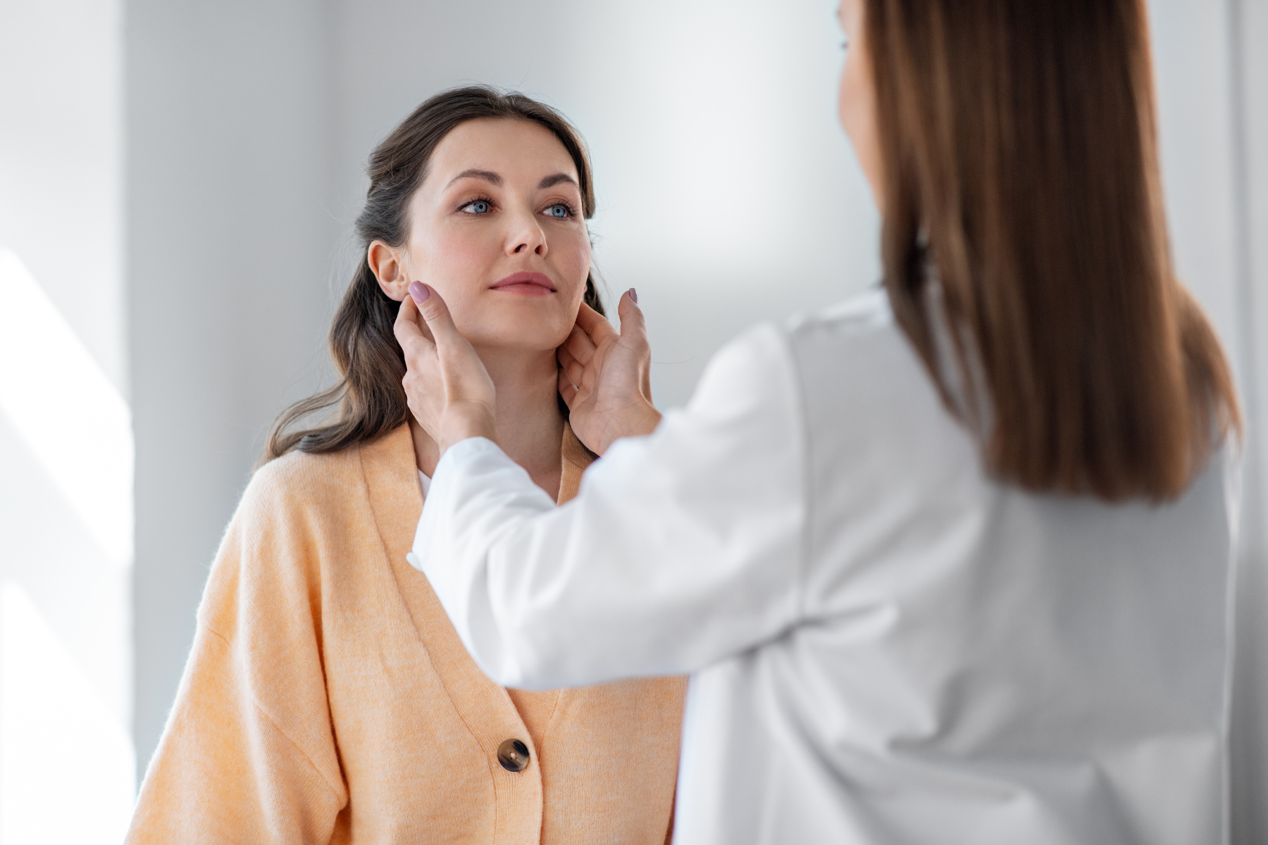 Doctor examining patient's lymph nodes, as enlarged lymph nodes are a common feature of Schnitzler Syndrome