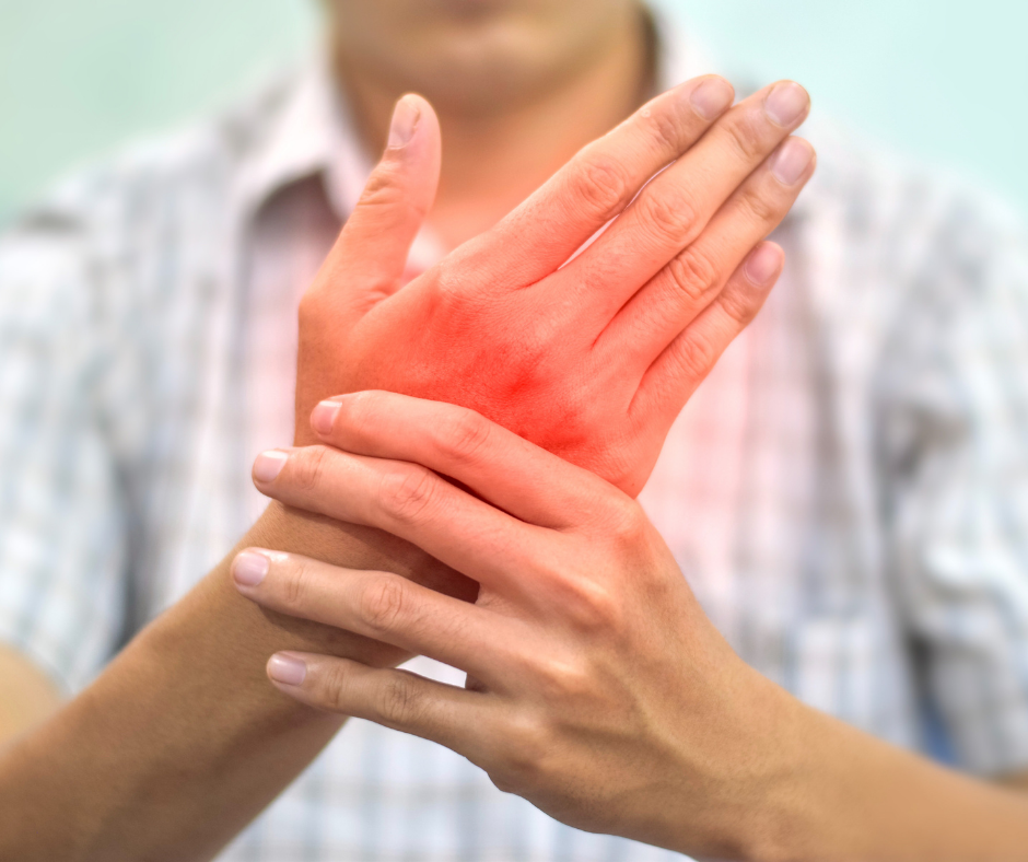 A person in a striped shirt holds their wrist, with a red highlighted area indicating joint pain