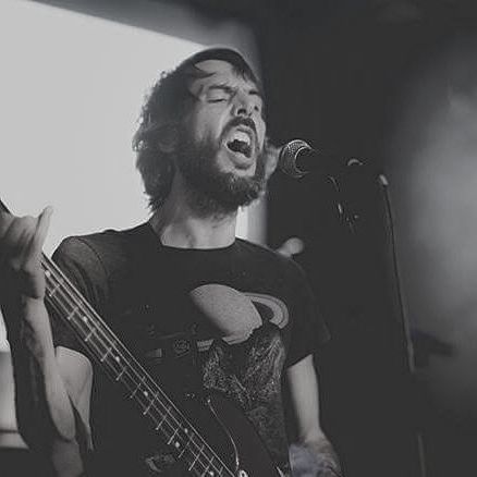 Ryan Reeves: Man with long dark hair playing bass guitar, captured mid-performance