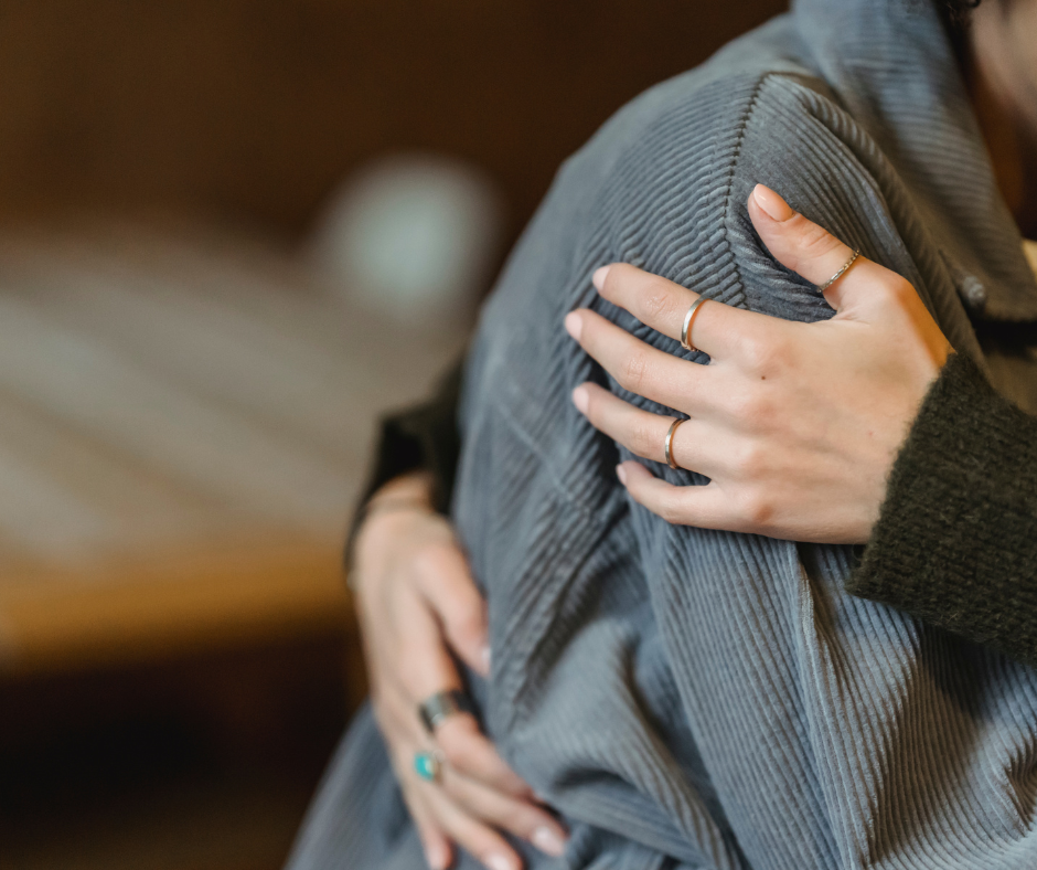 Two people hugging, only shoulders and hands are seen. 