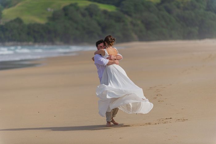 Pure Freude und so viel Liebe. Brautpaar am Strand von Neuseeland nach ihrer freien Trauung.
 