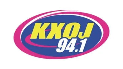 KXOJ 94.1 radio station logo with text in yellow over a blue and pink oval.