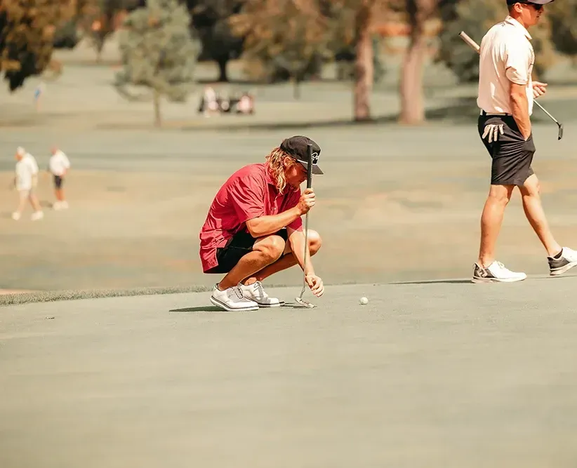 Two men are playing golf on a golf course.