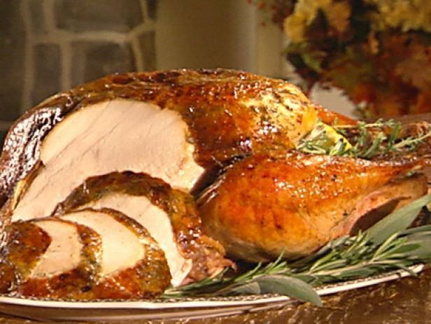 A roasted turkey is sitting on a plate on a table.