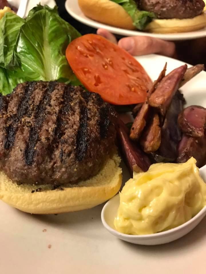 A hamburger with lettuce tomato and bacon on a bun