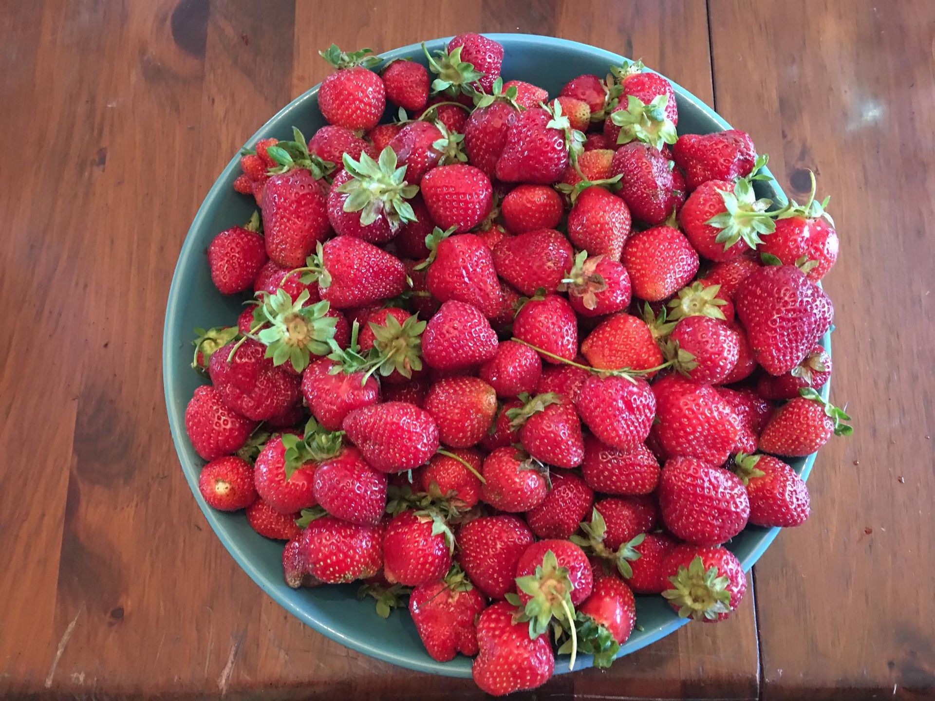 A bowl of strawberries on a wooden table