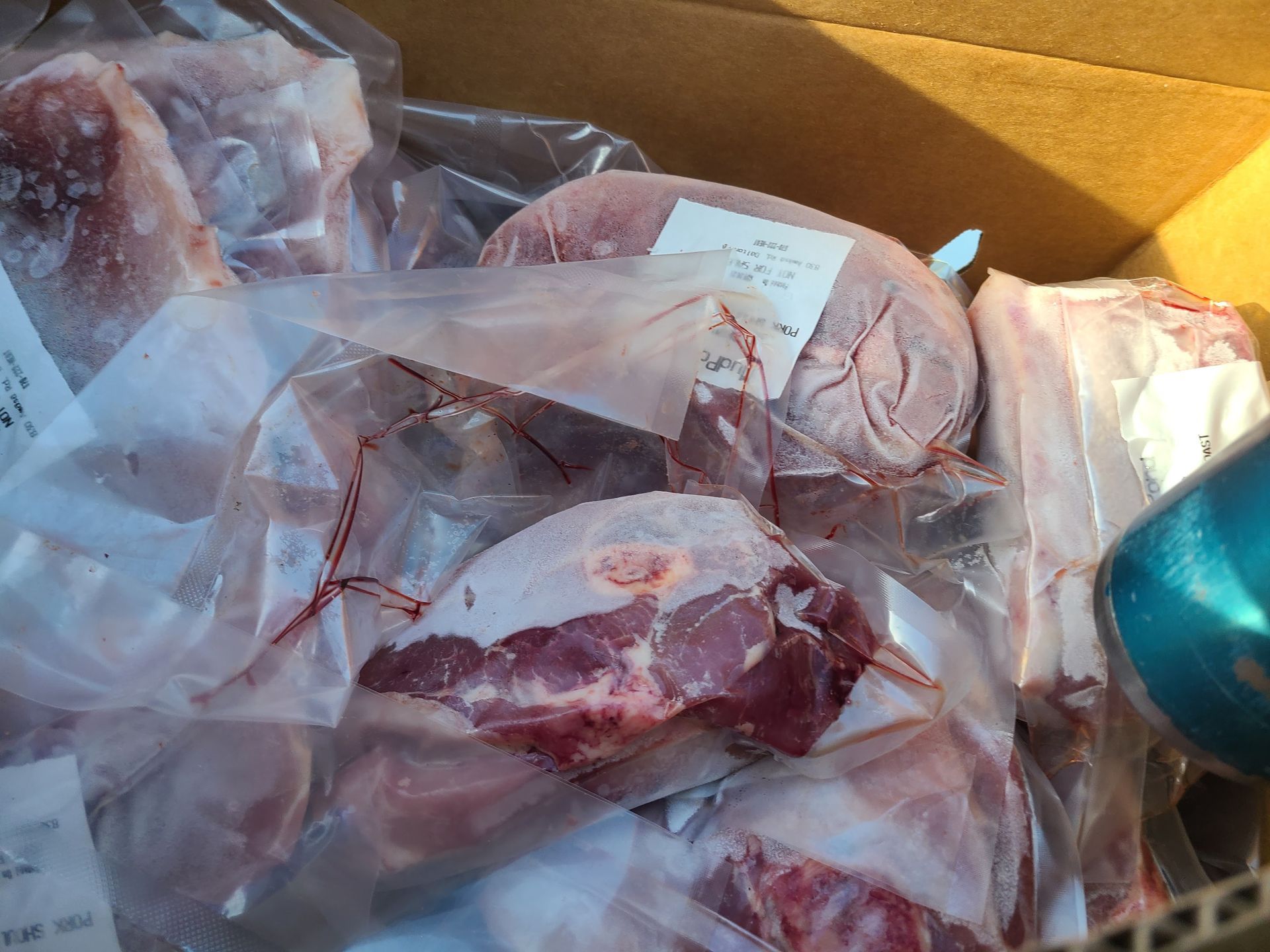 A box filled with lots of meat and a can of soda