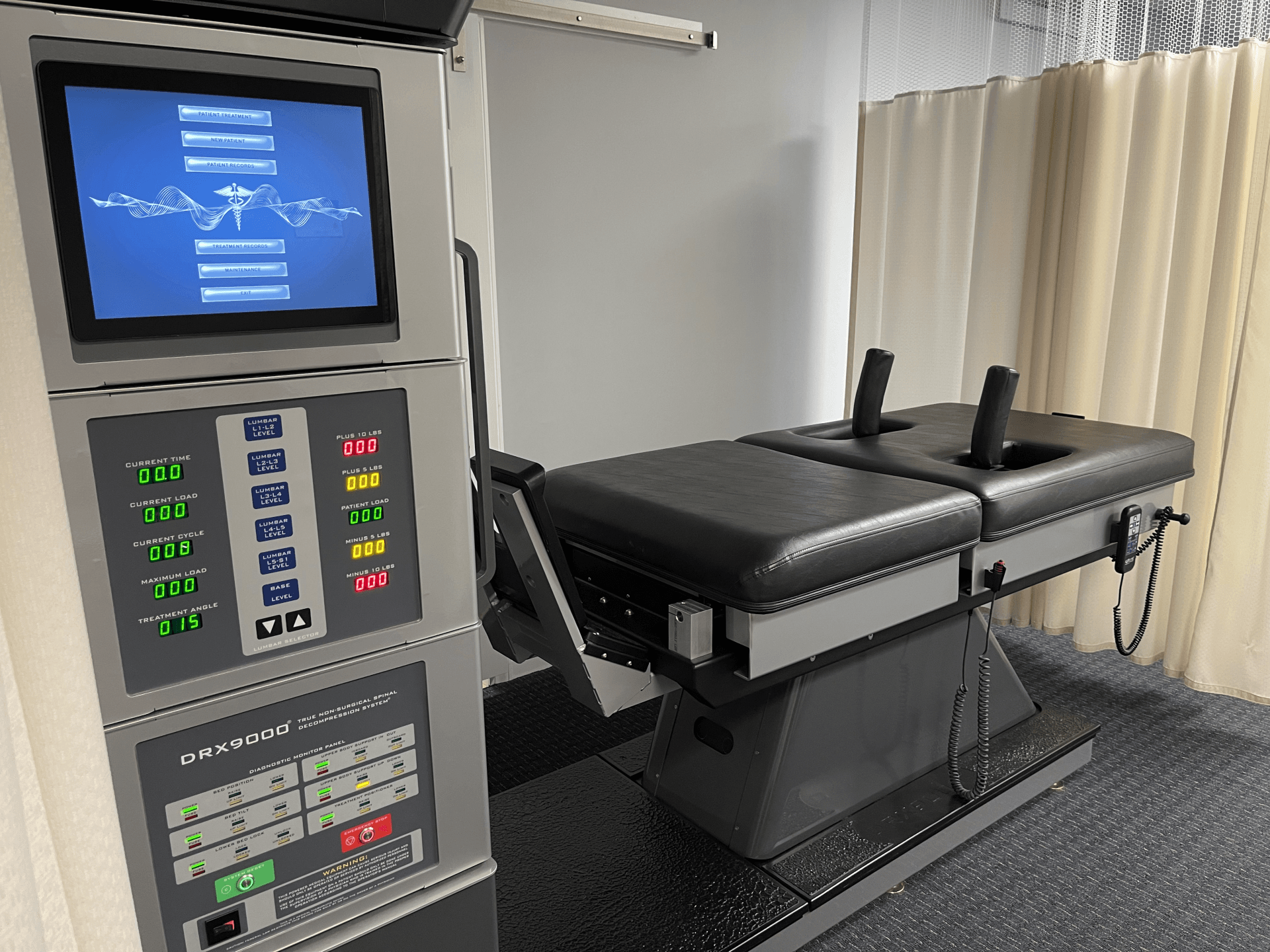 Chiropractic table with control panel in a treatment room.