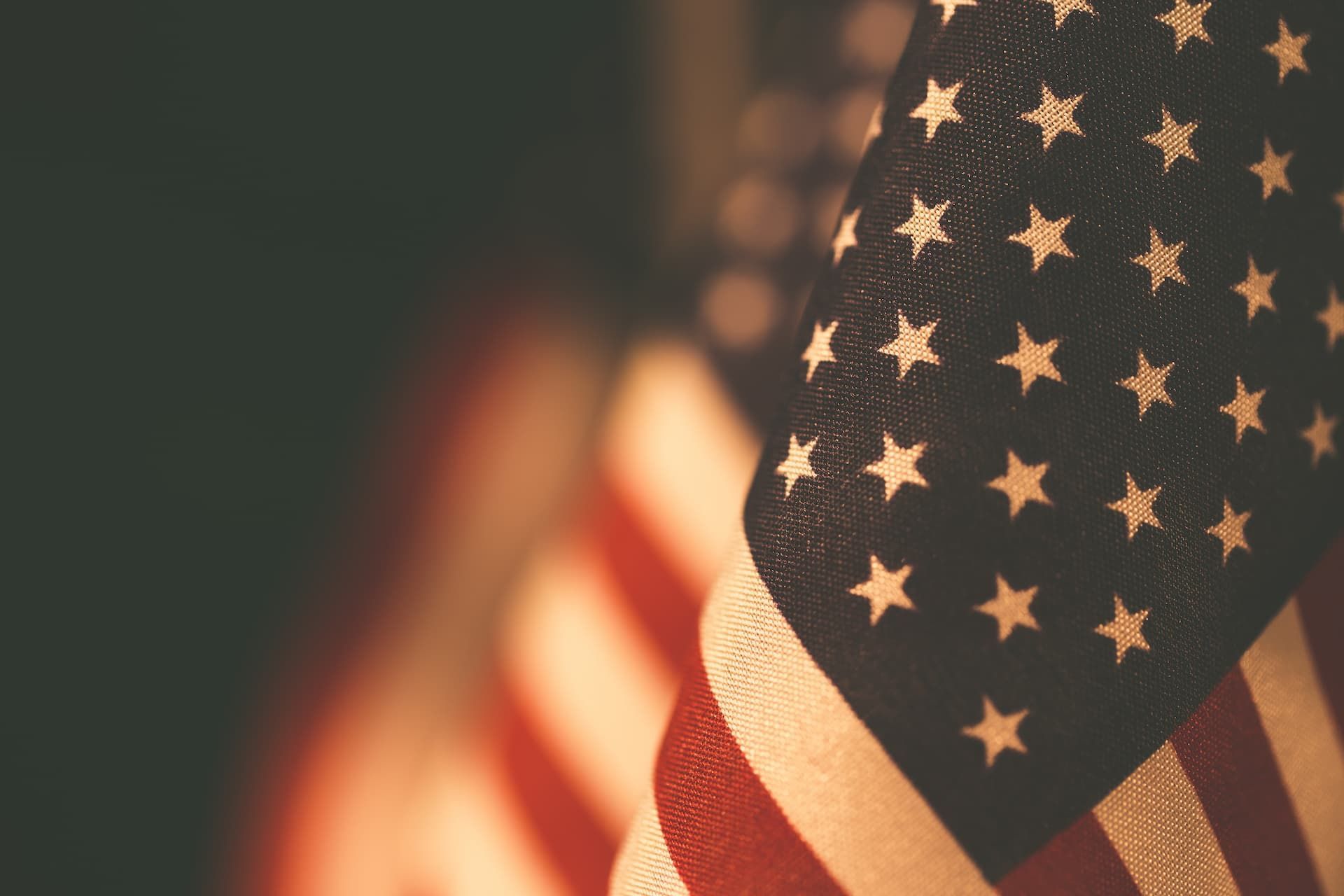 Close-up of a folded American flag featuring its blue field with white stars and red and white stripes.