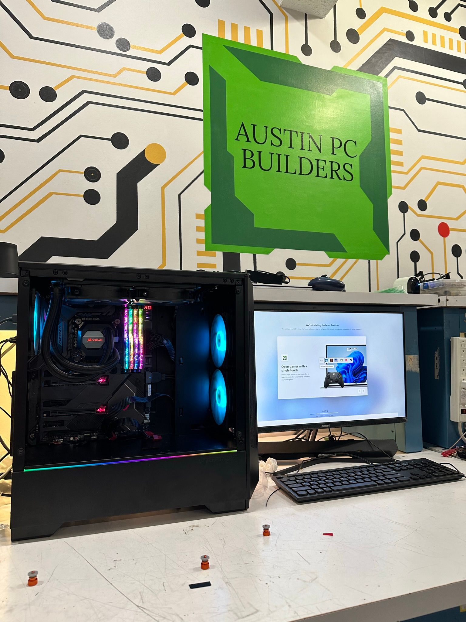 A computer is sitting on a desk under a sign that says austin pc builders