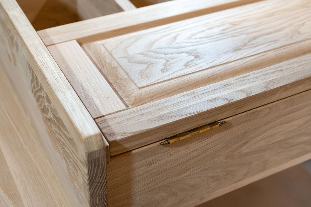 A close up of a wooden drawer with a brass handle.