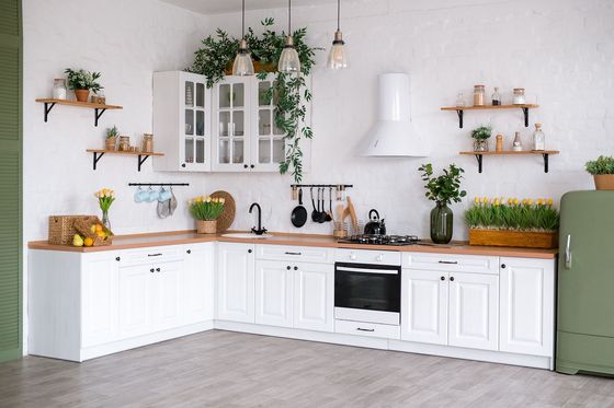 A kitchen with white cabinets and a green refrigerator.