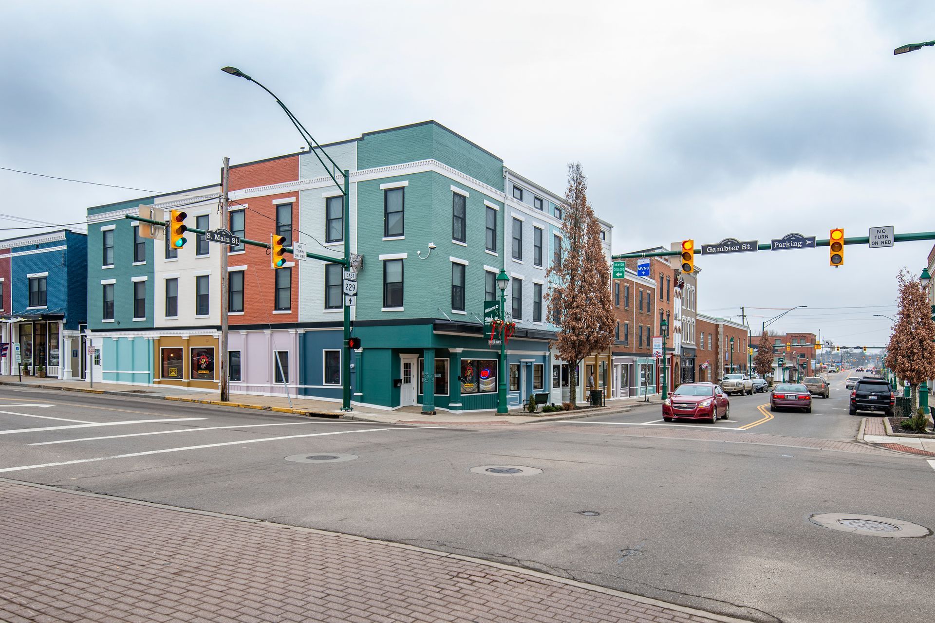 A busy intersection with a green building in the middle