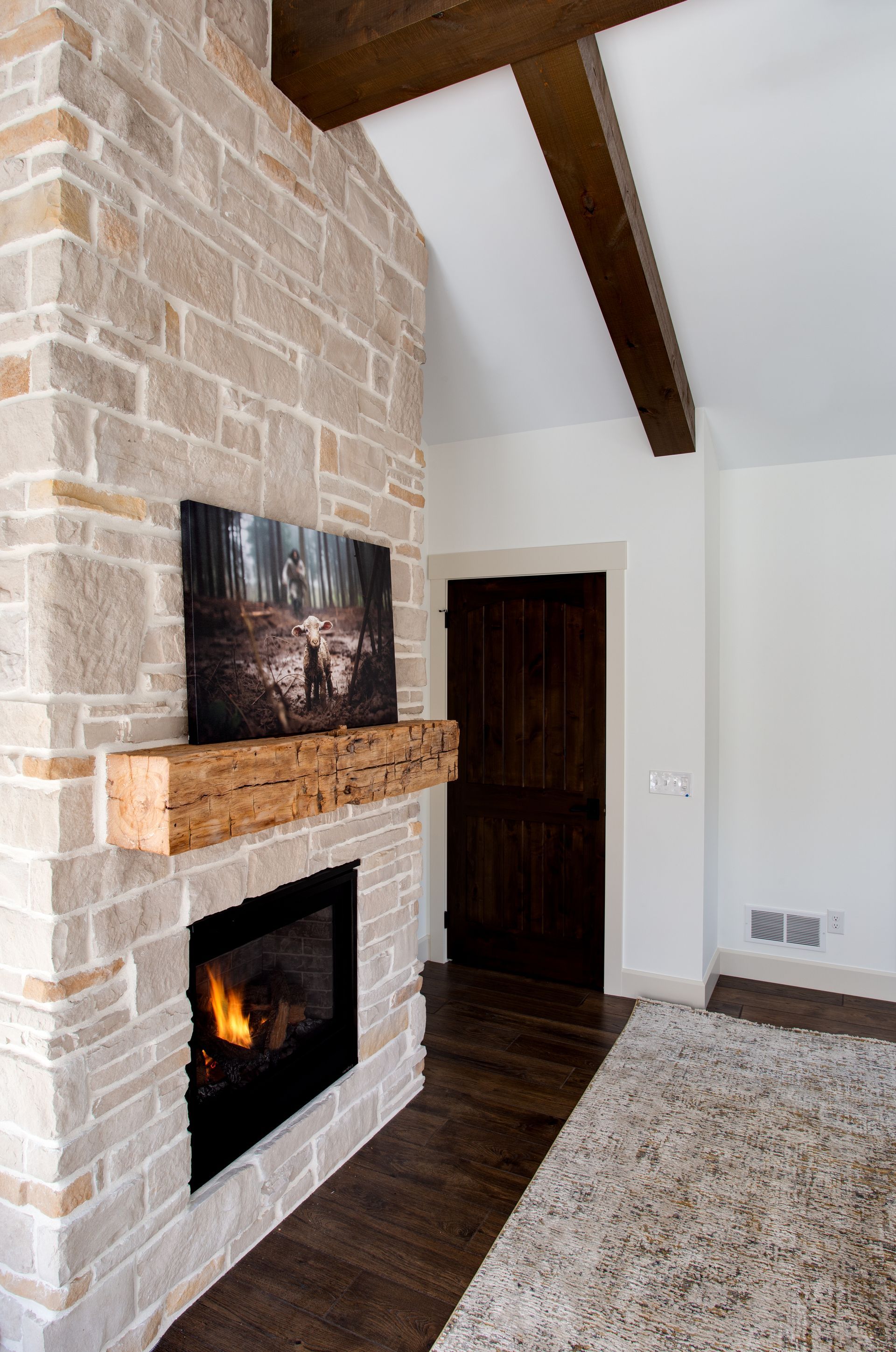 A living room with a fireplace and a painting on the wall.