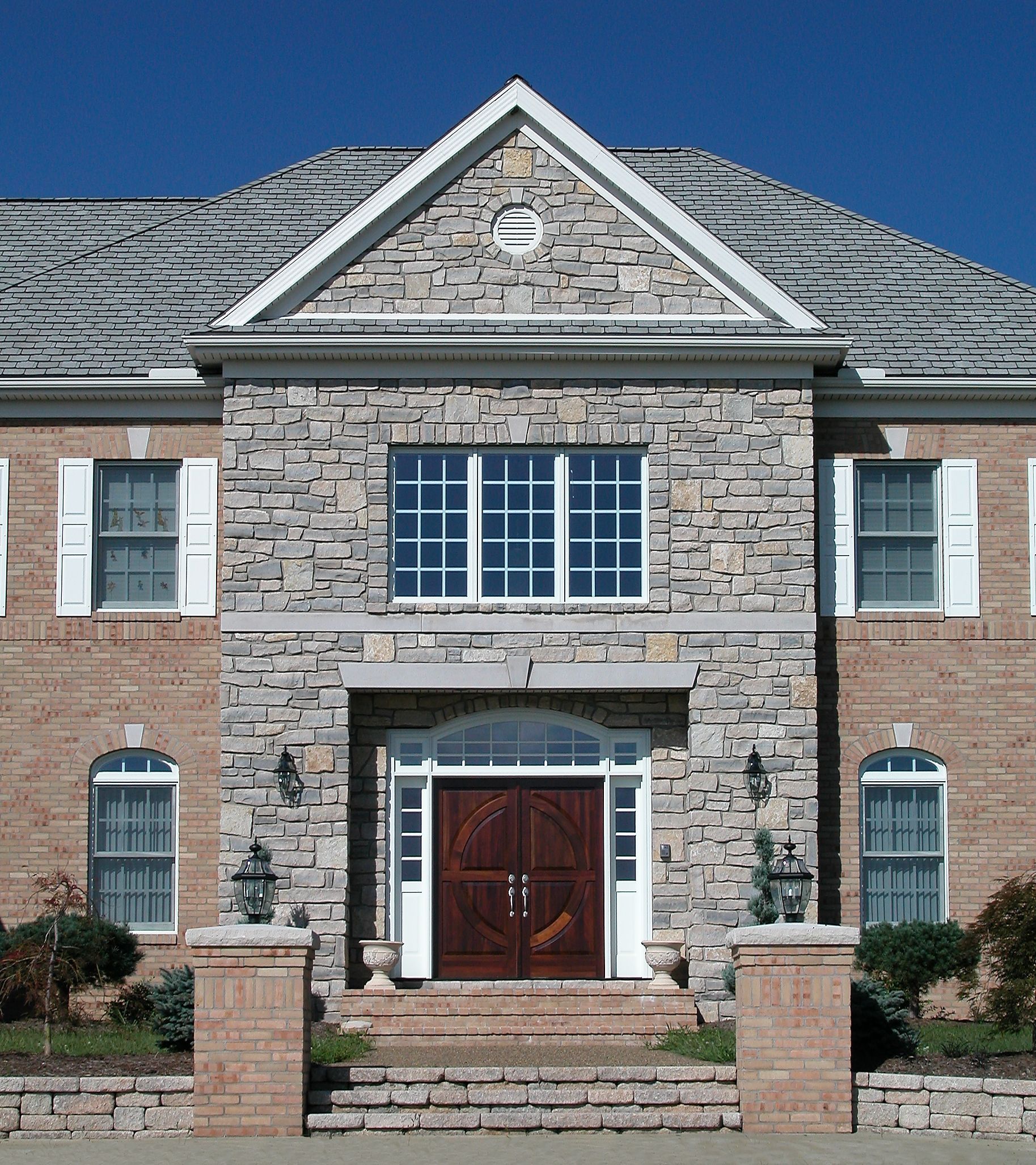 A large brick house with white shutters on the windows.