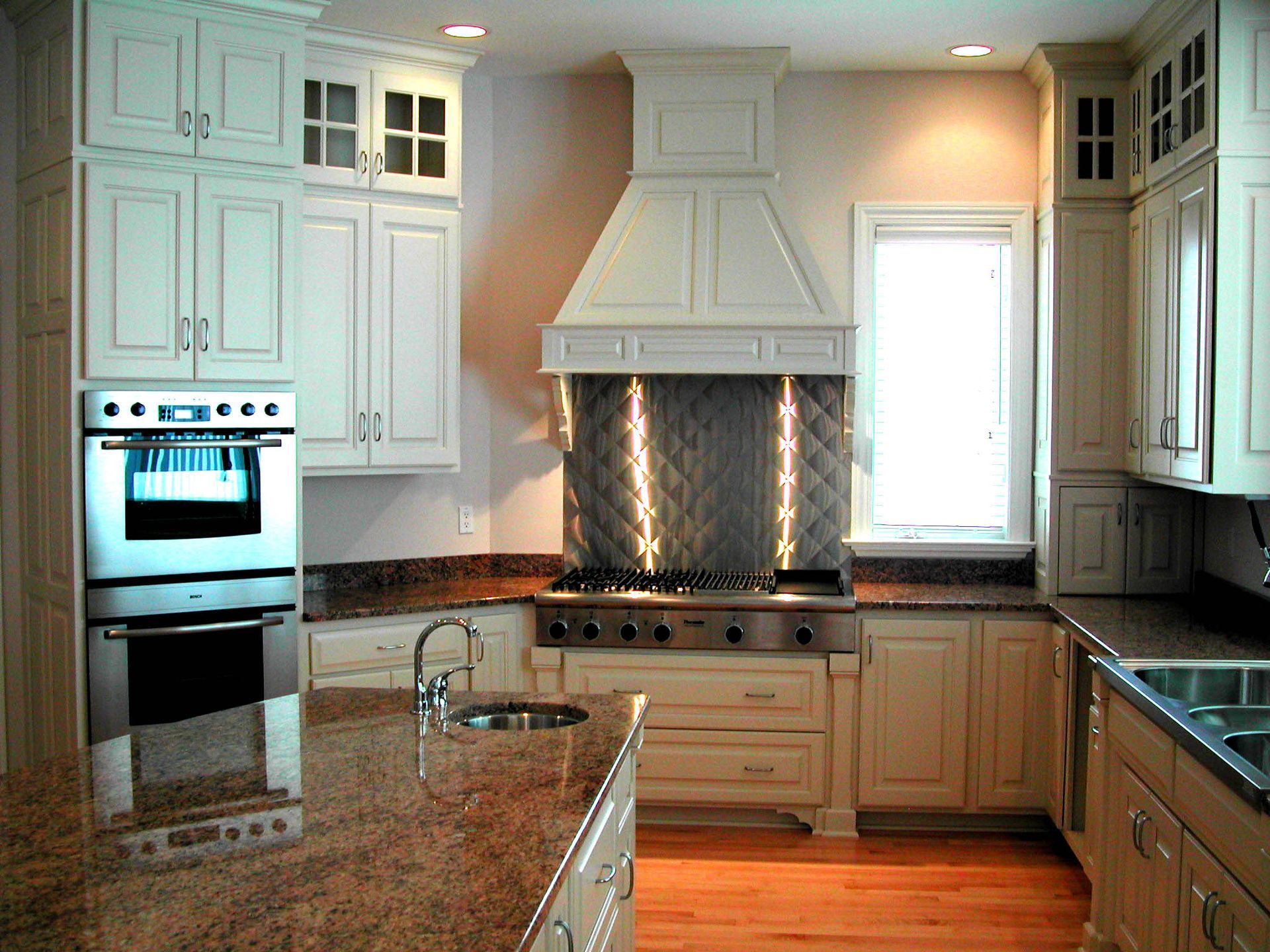 A kitchen with white cabinets and stainless steel appliances.