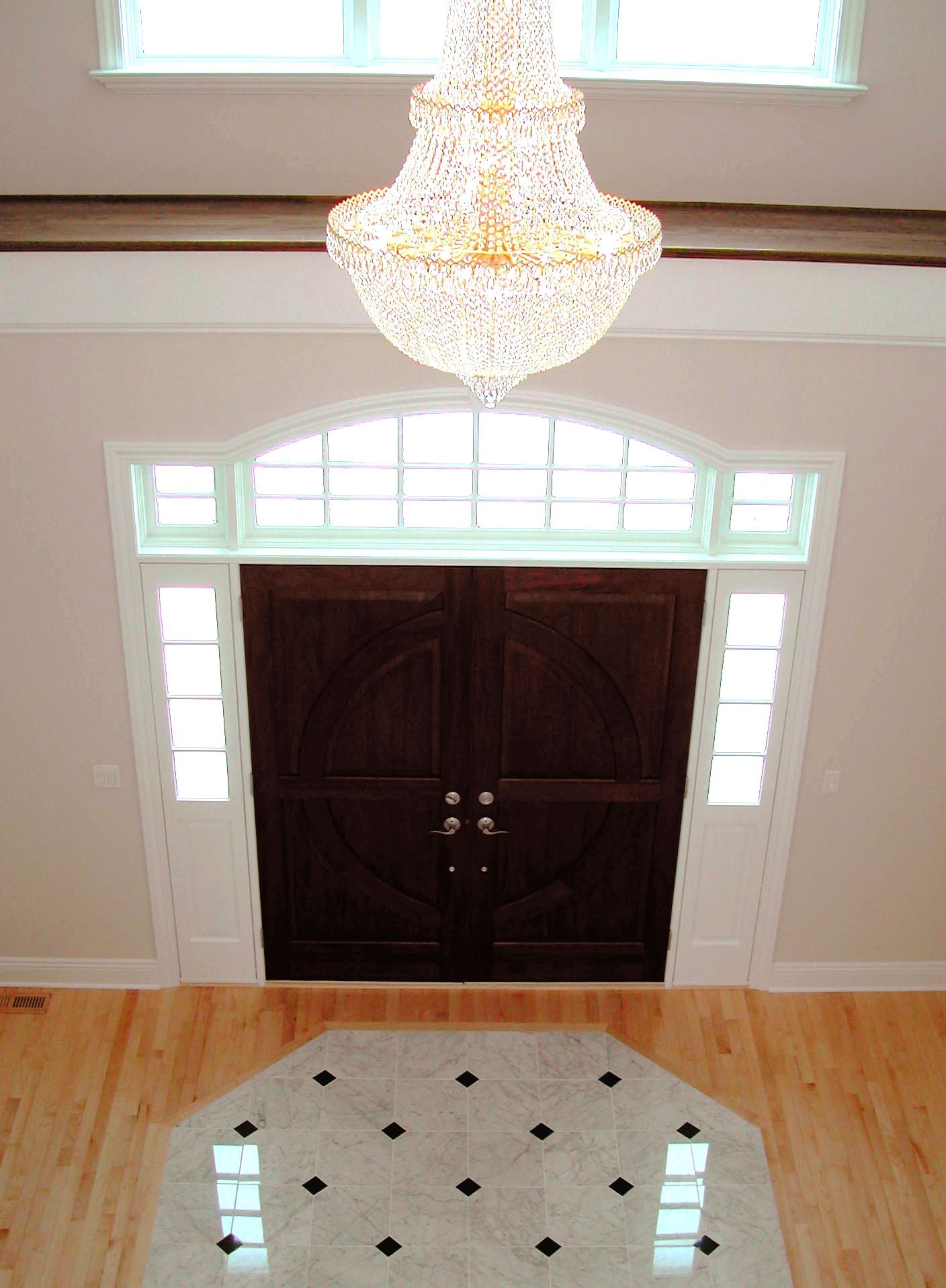 A large chandelier hangs above a double door.