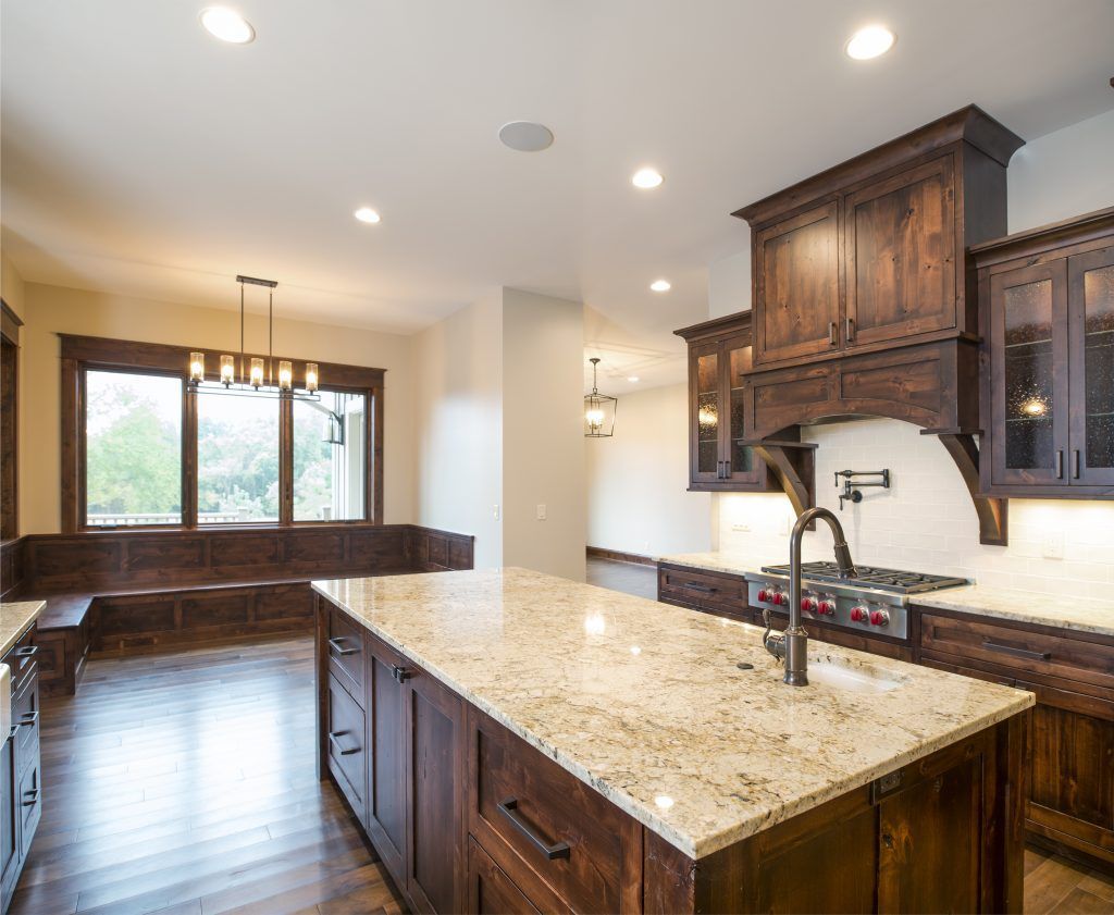 A kitchen with granite counter tops and wooden cabinets.