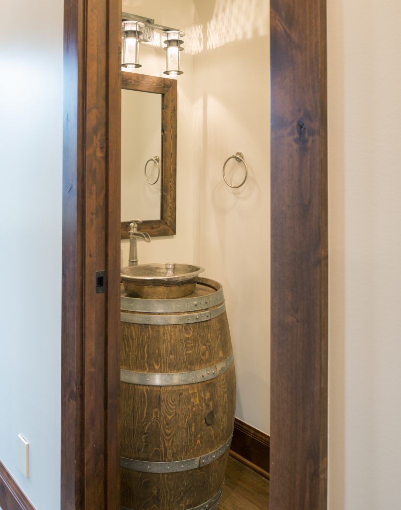 A bathroom with a wooden barrel sink and mirror