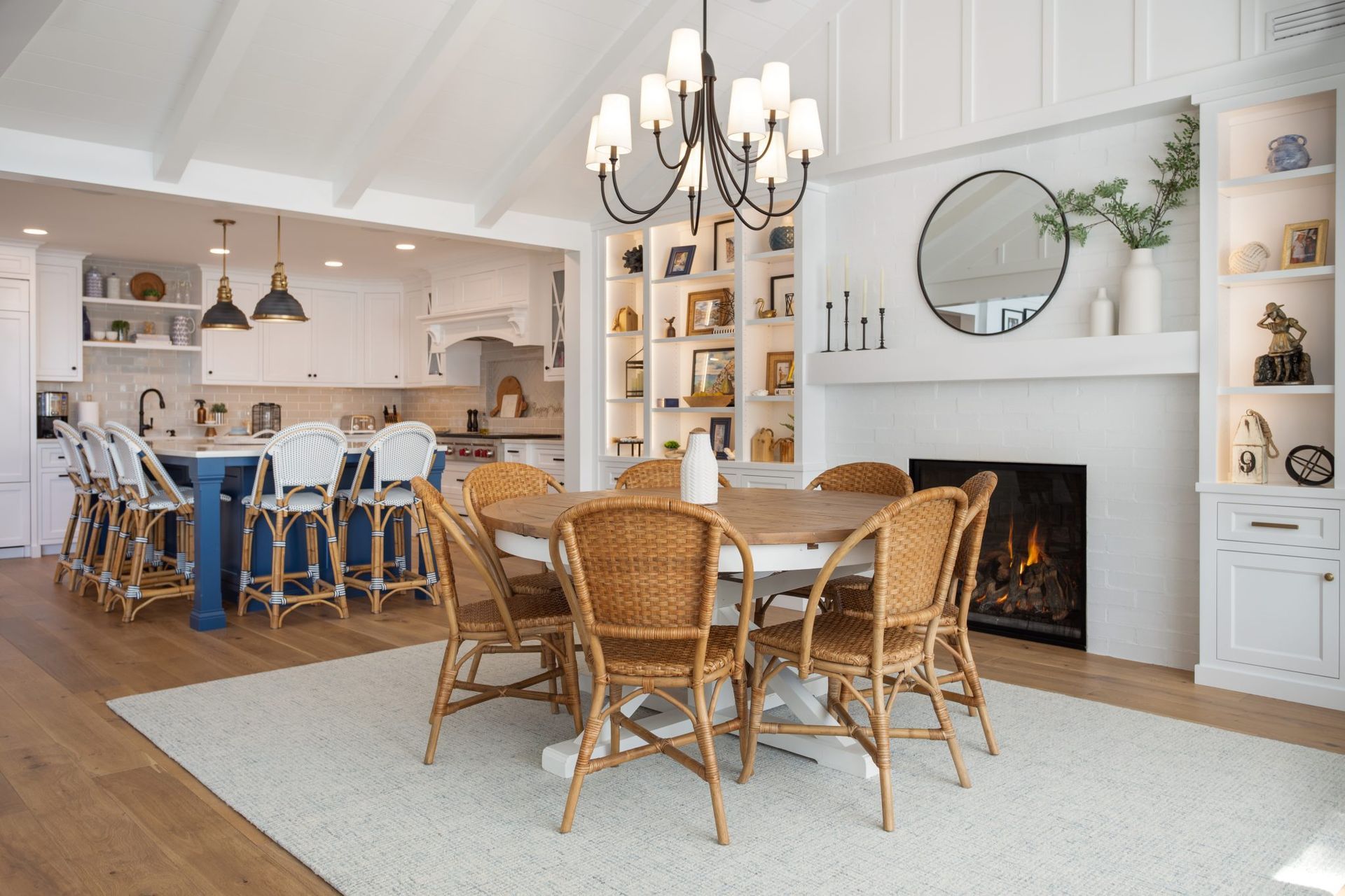 A dining room with a table and chairs and a fireplace.