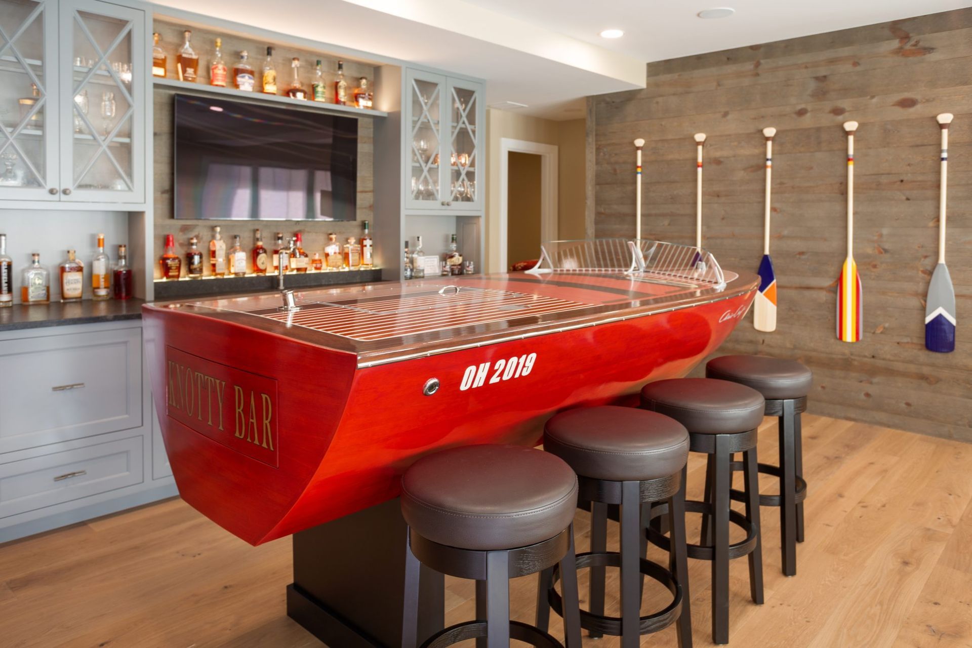A room with a red boat shaped bar and stools.