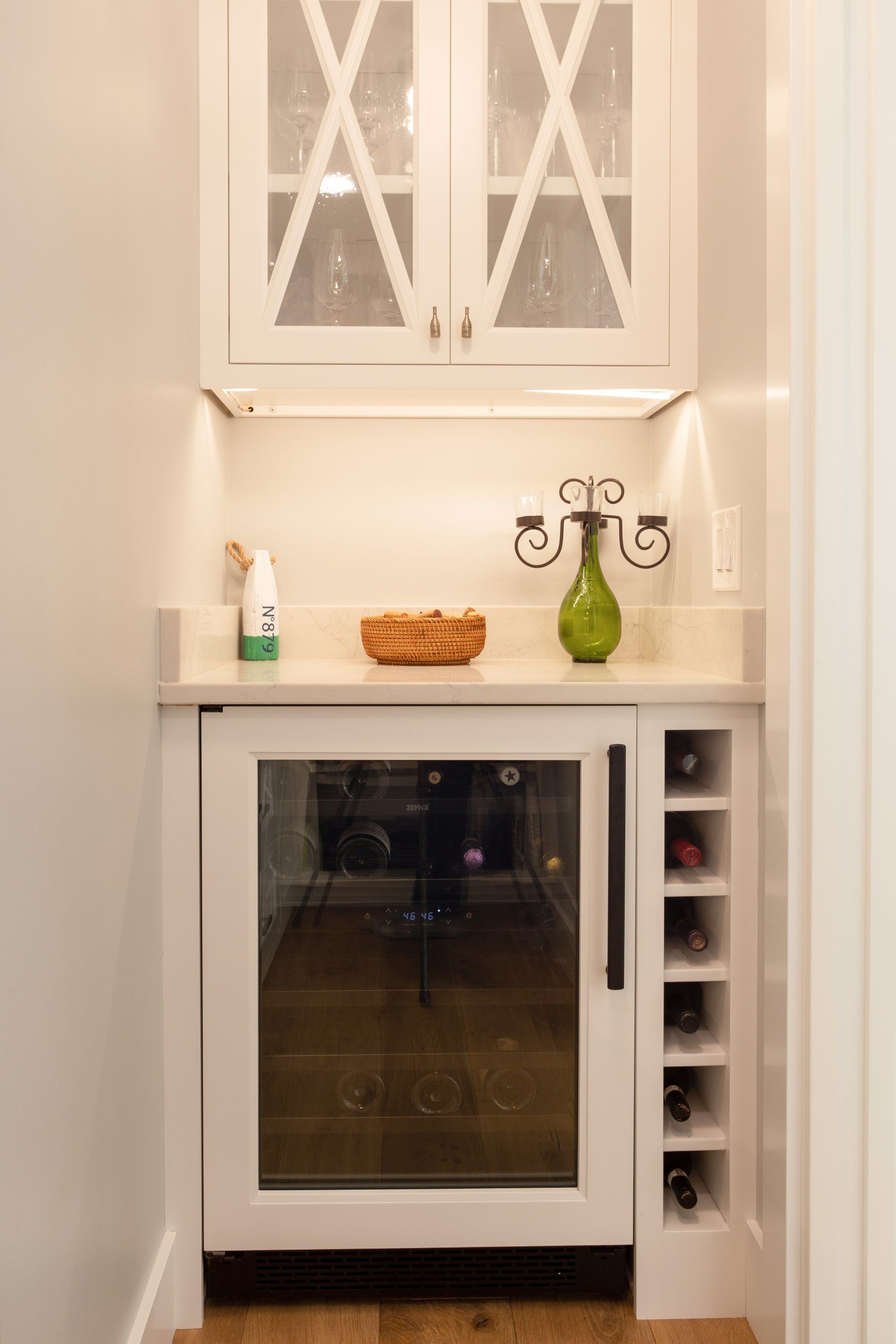 A small kitchen with a wine cooler and a wine rack.