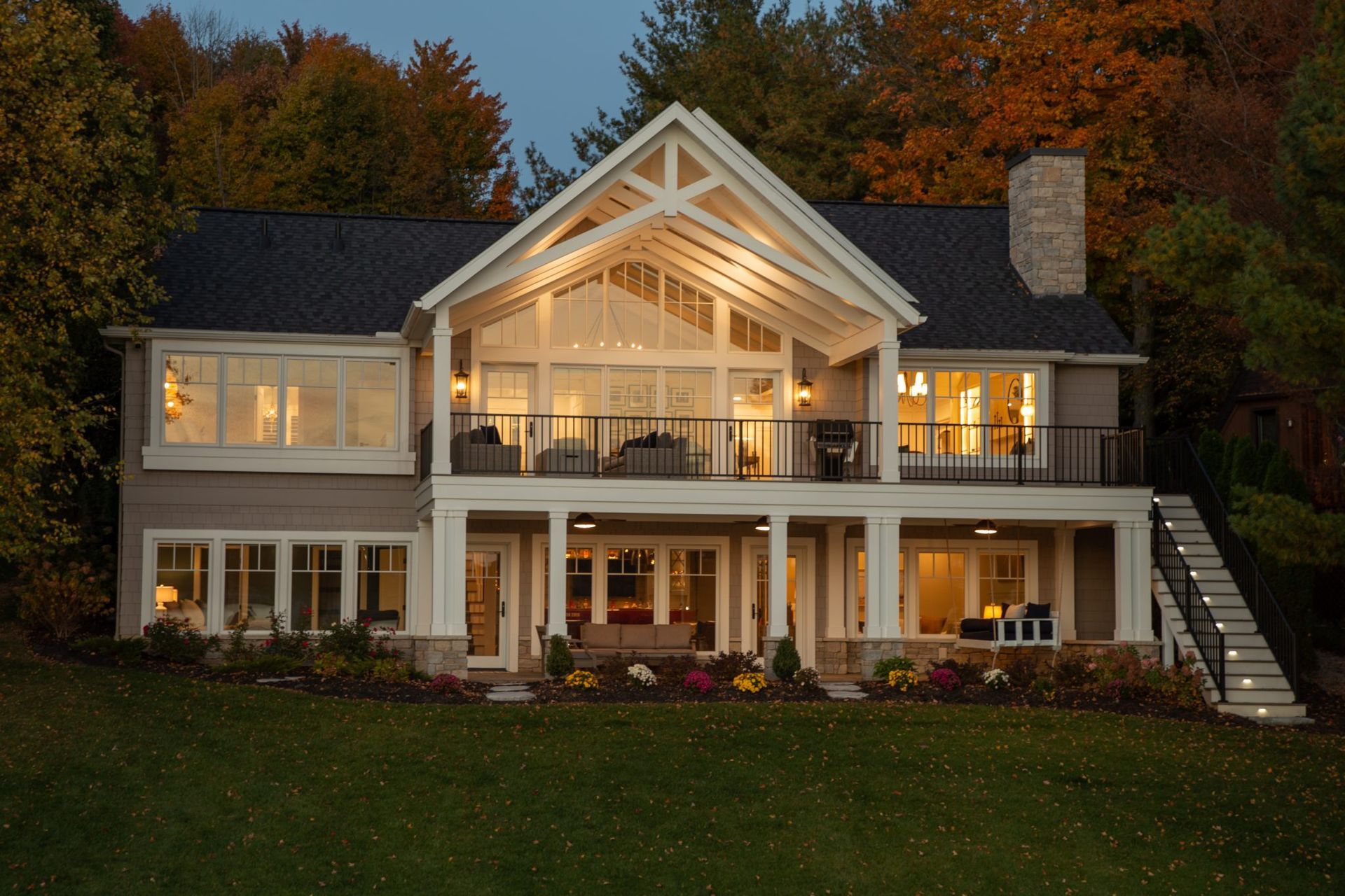 A large house with a lot of windows is lit up at night.