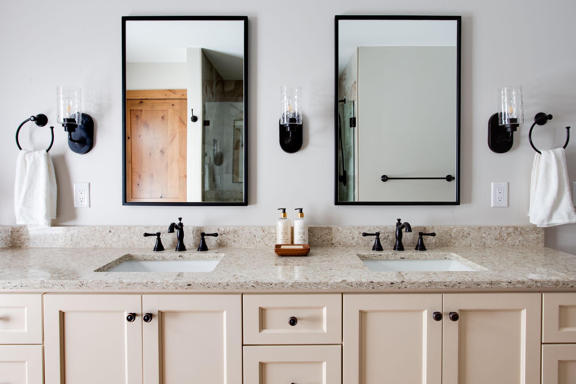 A bathroom with two sinks and two mirrors.