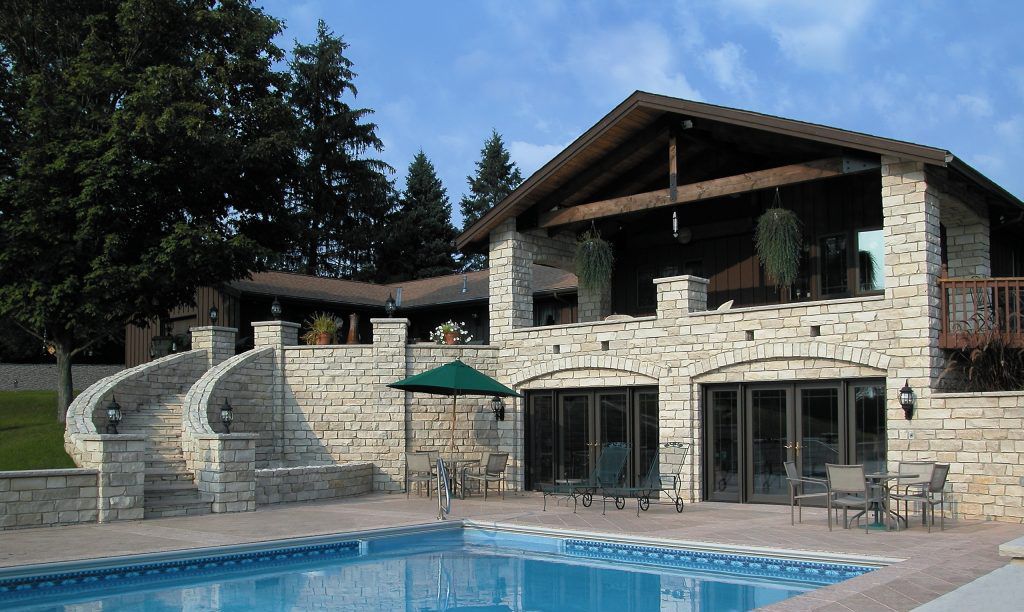 A large house with a swimming pool in front of it.