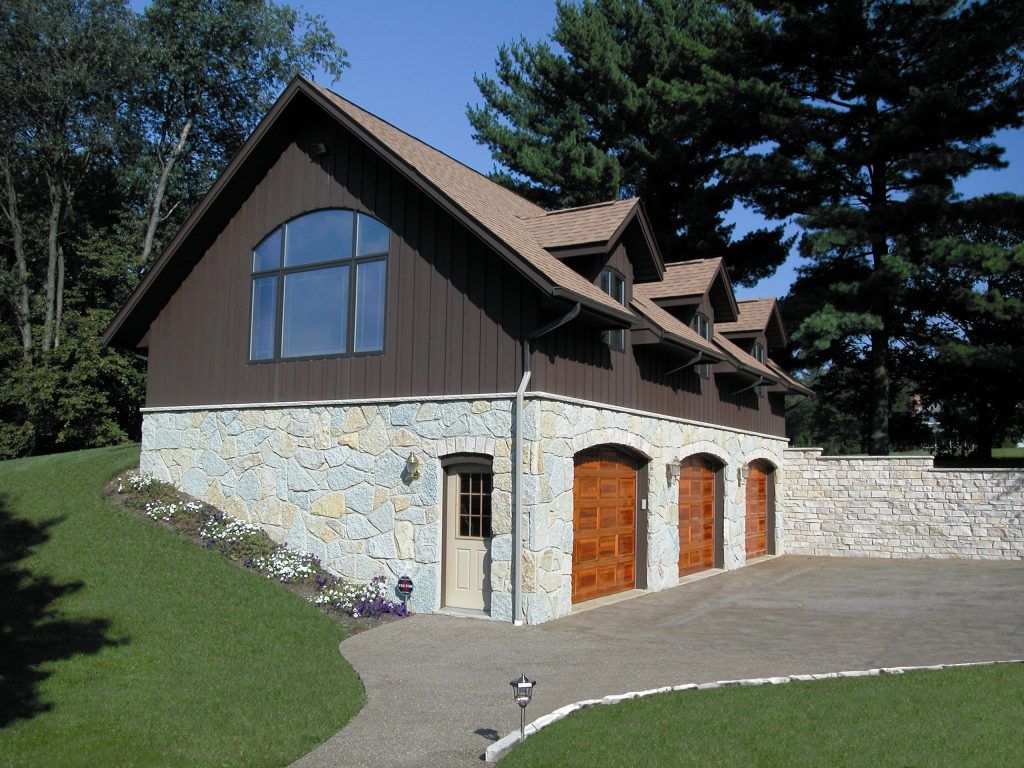 A house with three garage doors and a large window.