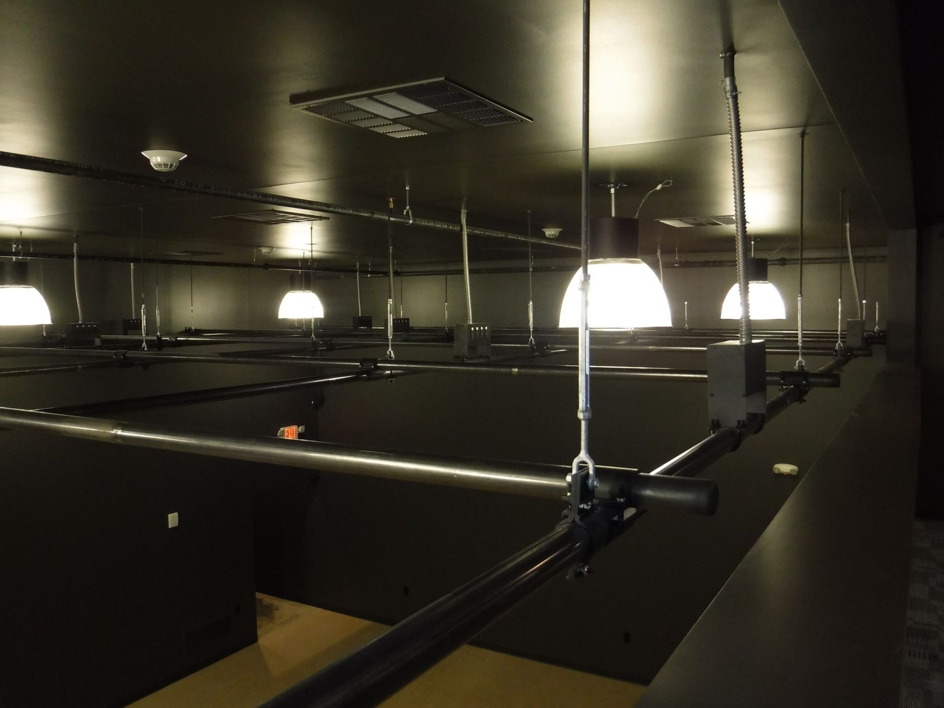 A dark room with a lot of lights hanging from the ceiling.