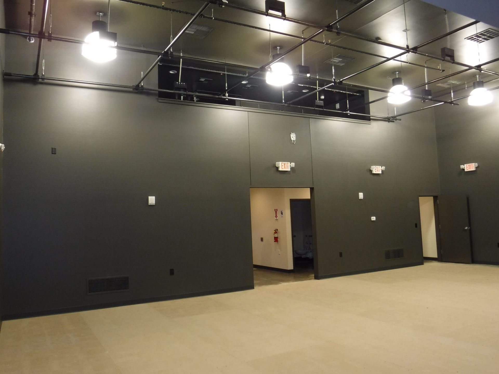 An empty room with black walls and a door.