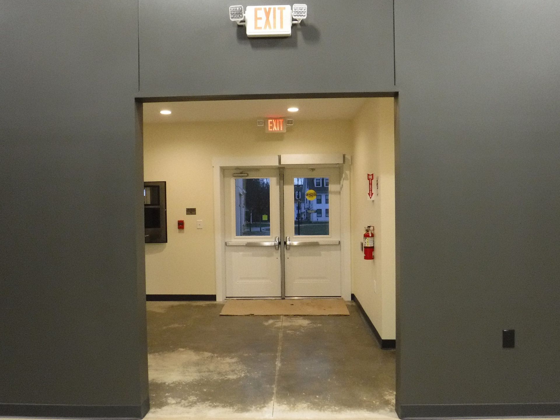An exit sign is above a doorway in a building.