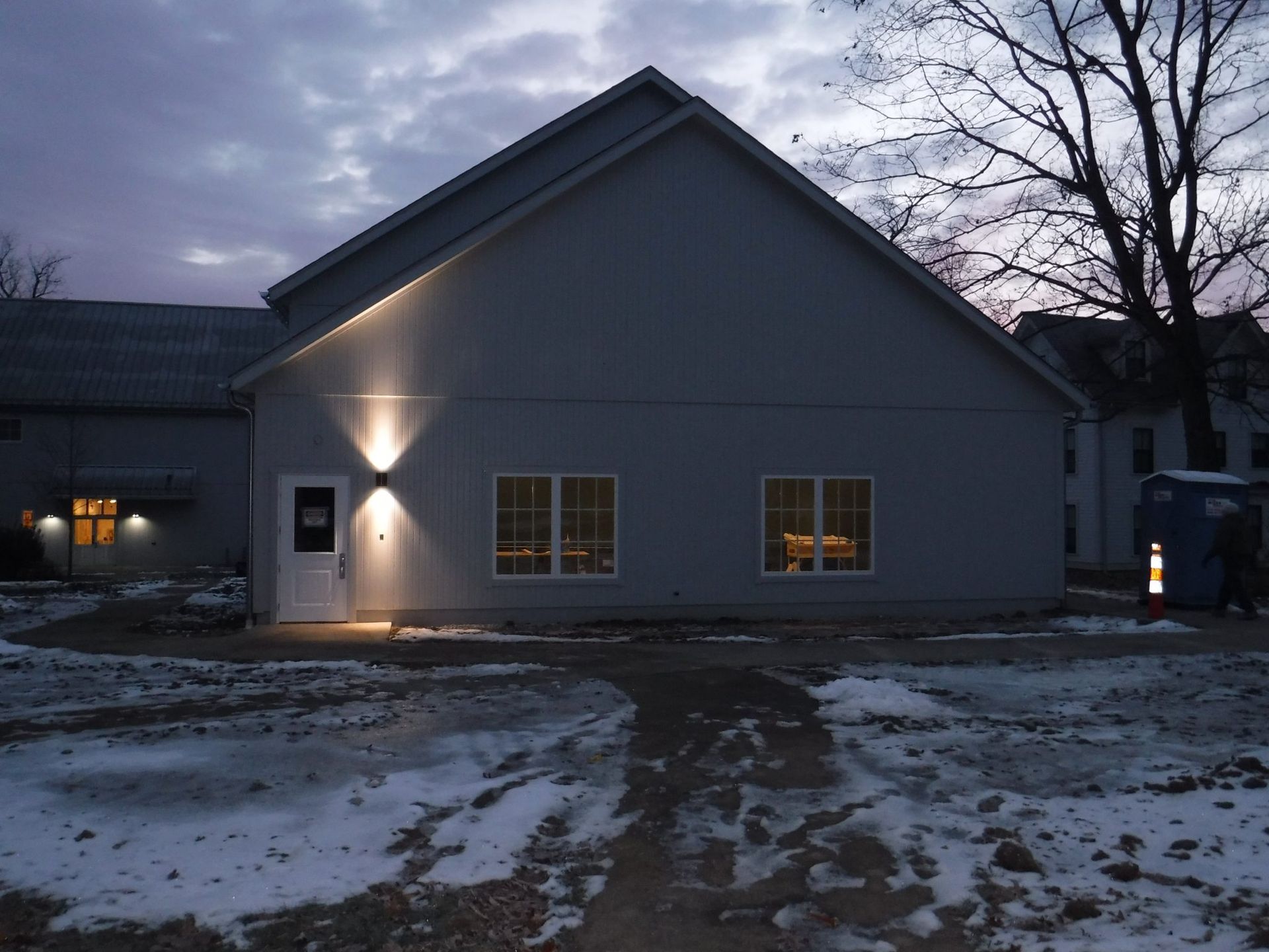 A house with a lot of windows is lit up at night.
