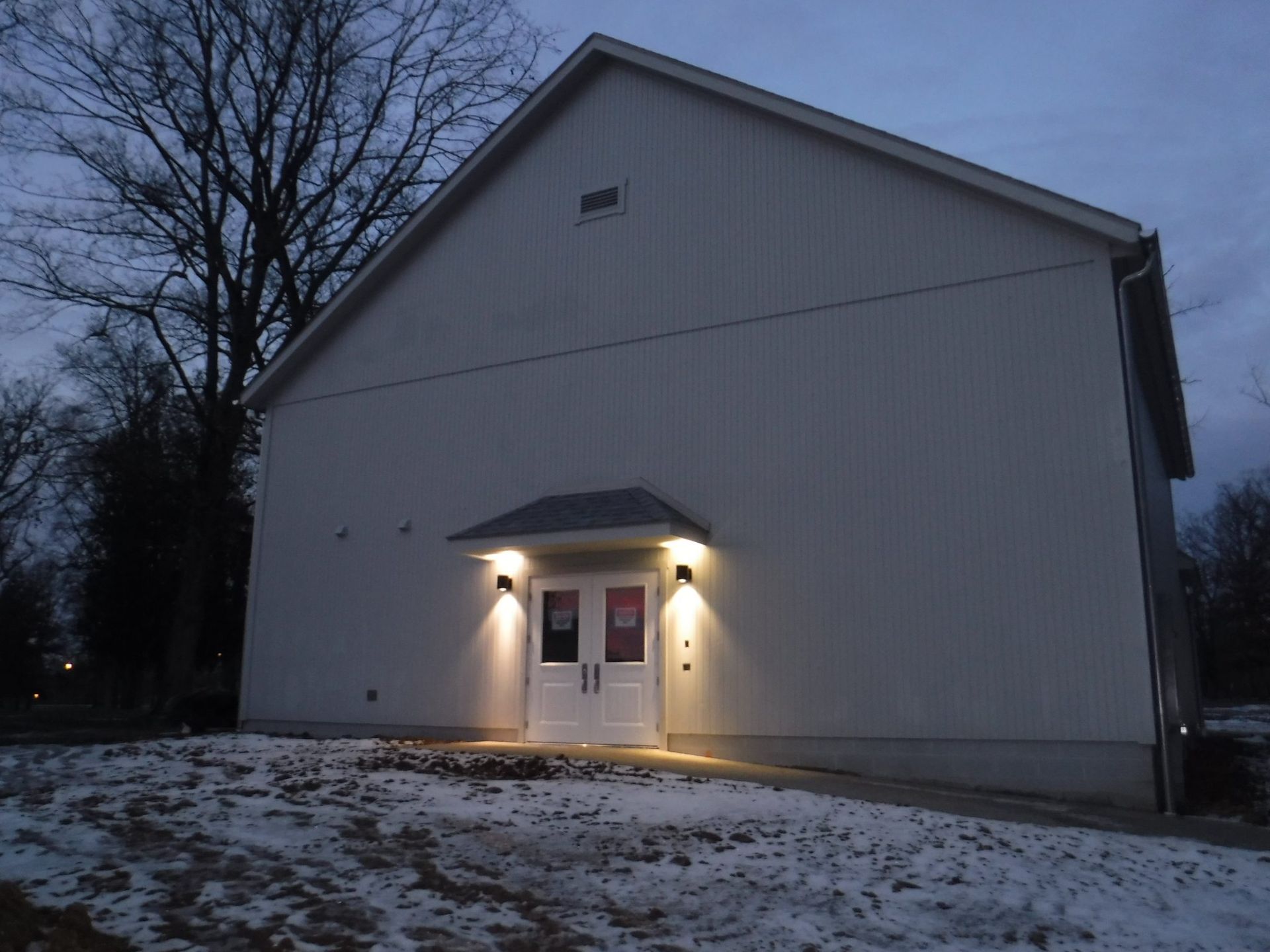 A white building with a roof that is covered in snow.