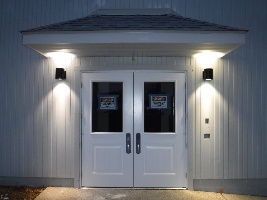 A white door with a sign on it that says exit.