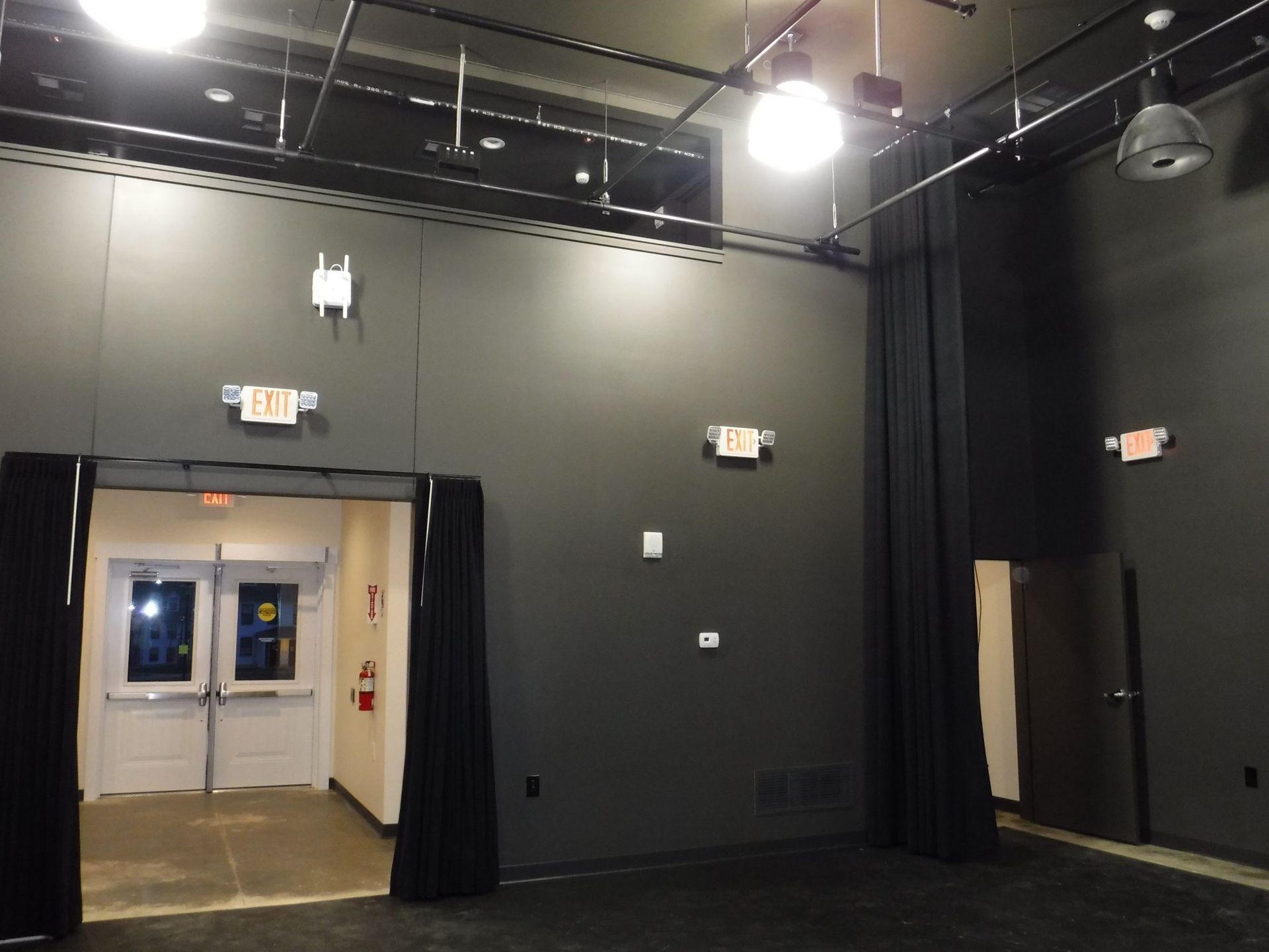 An empty room with an exit sign on the wall.