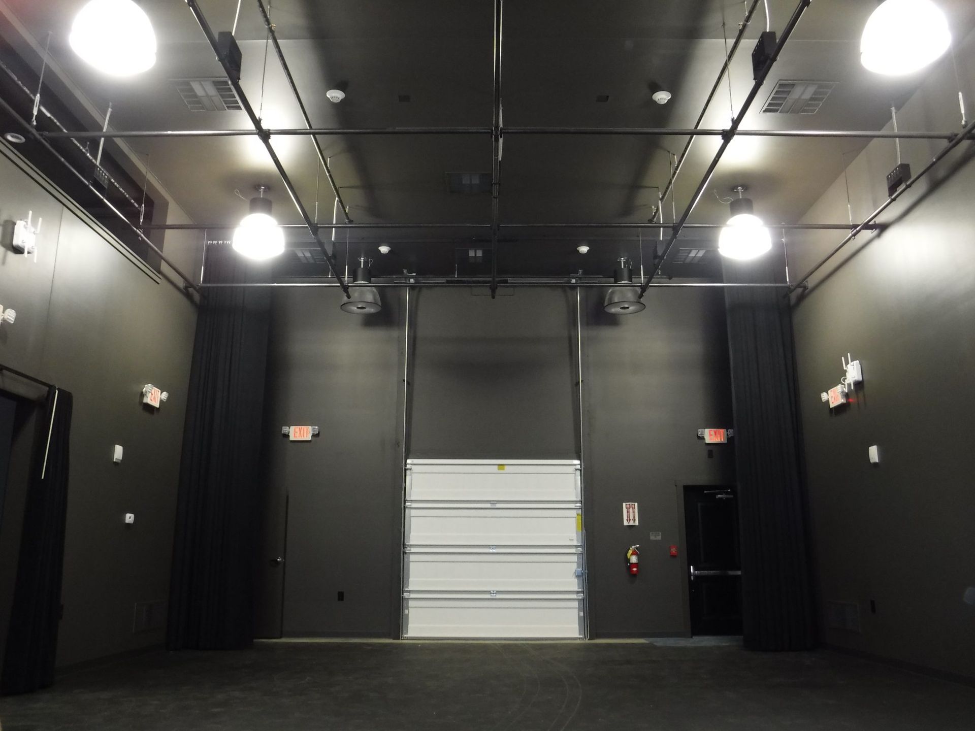 A large empty room with a white garage door.