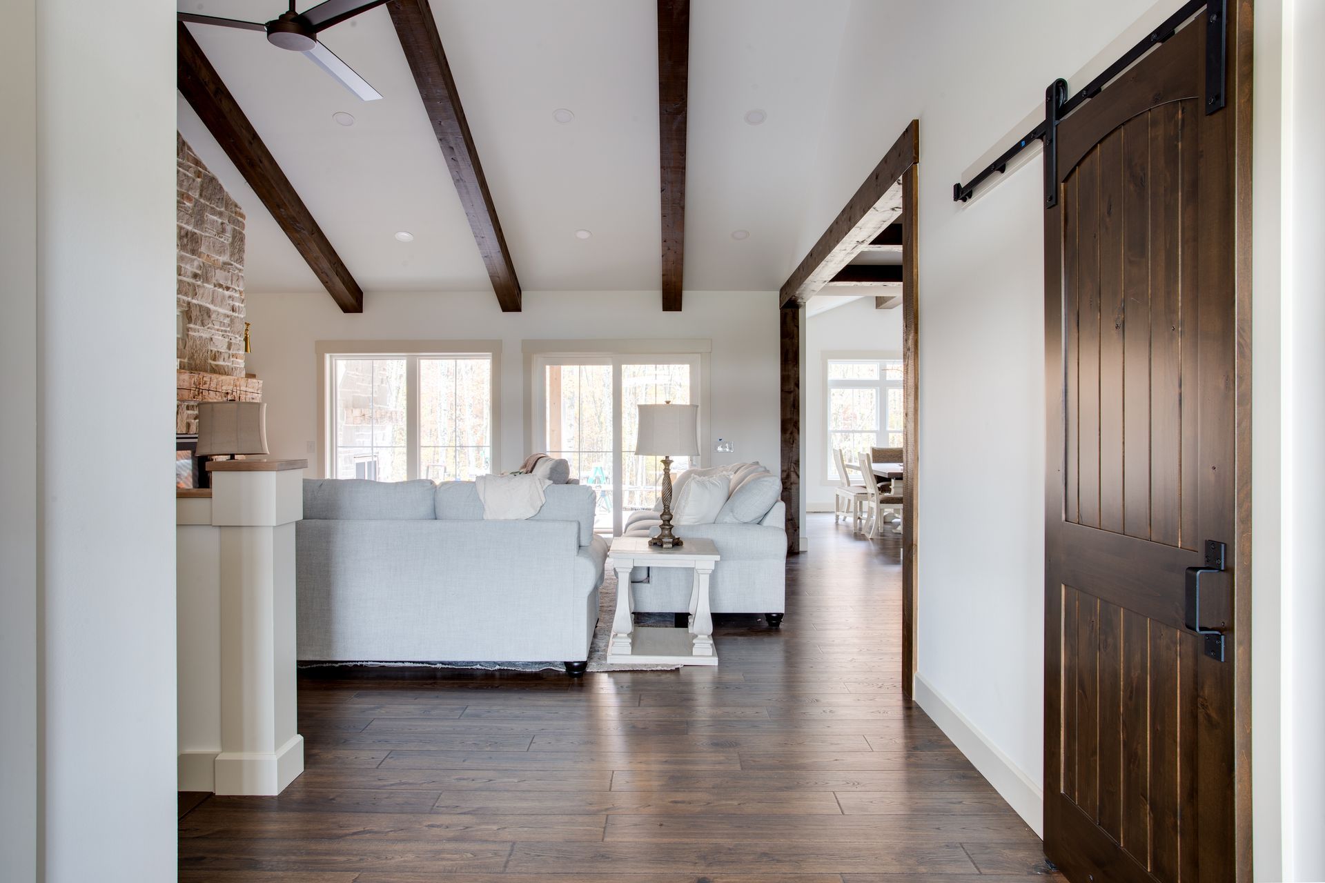 A living room with a white couch and a sliding barn door.