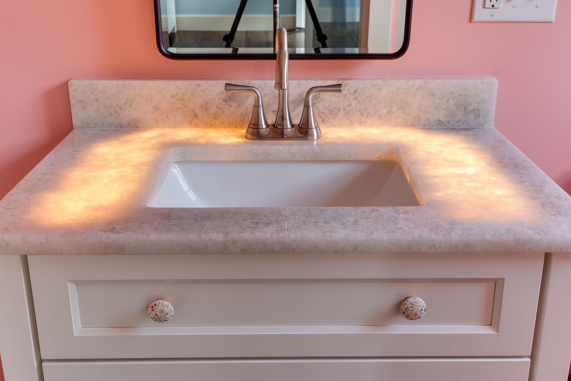A bathroom vanity with a sink and a mirror.
