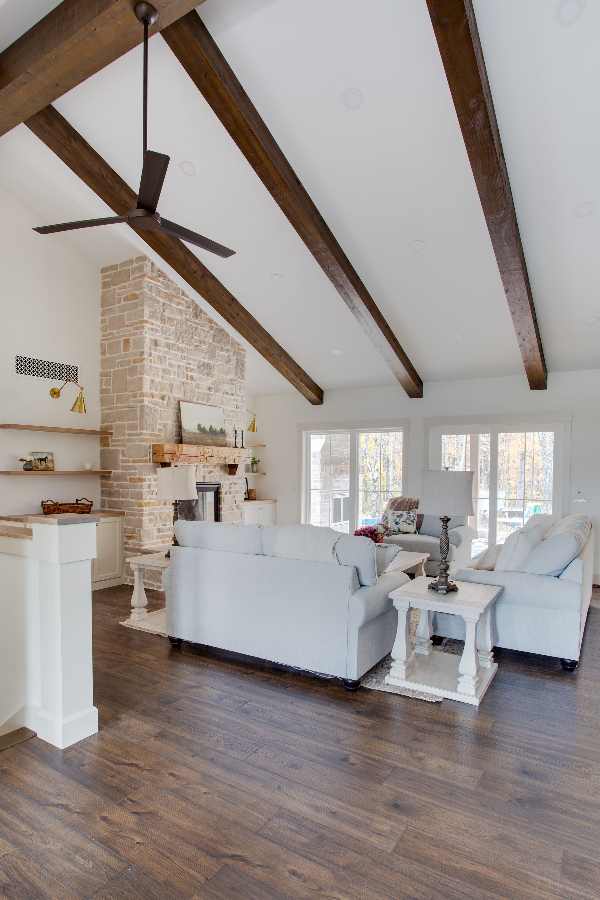 A living room with a ceiling fan and a fireplace.