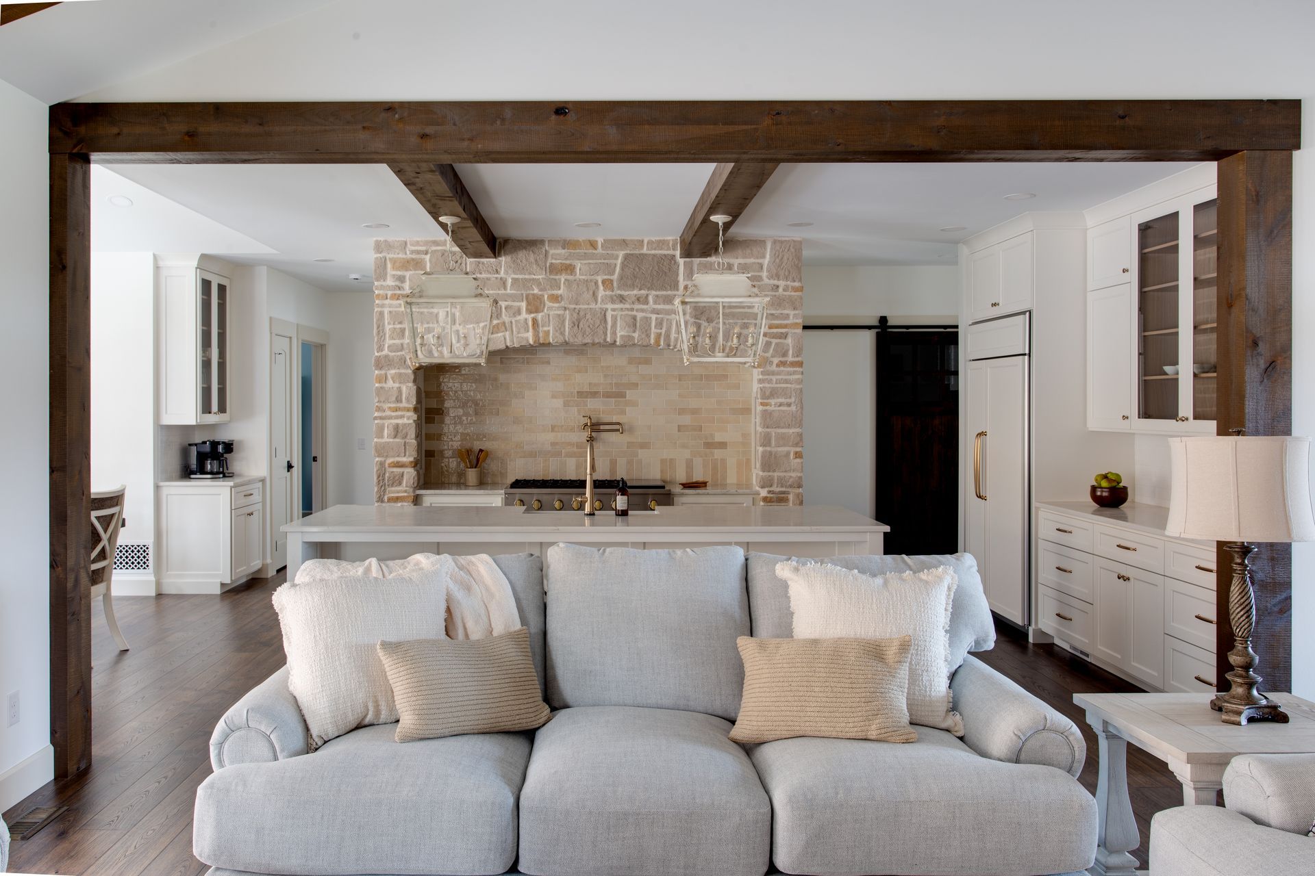 A living room with a couch and a kitchen in the background.