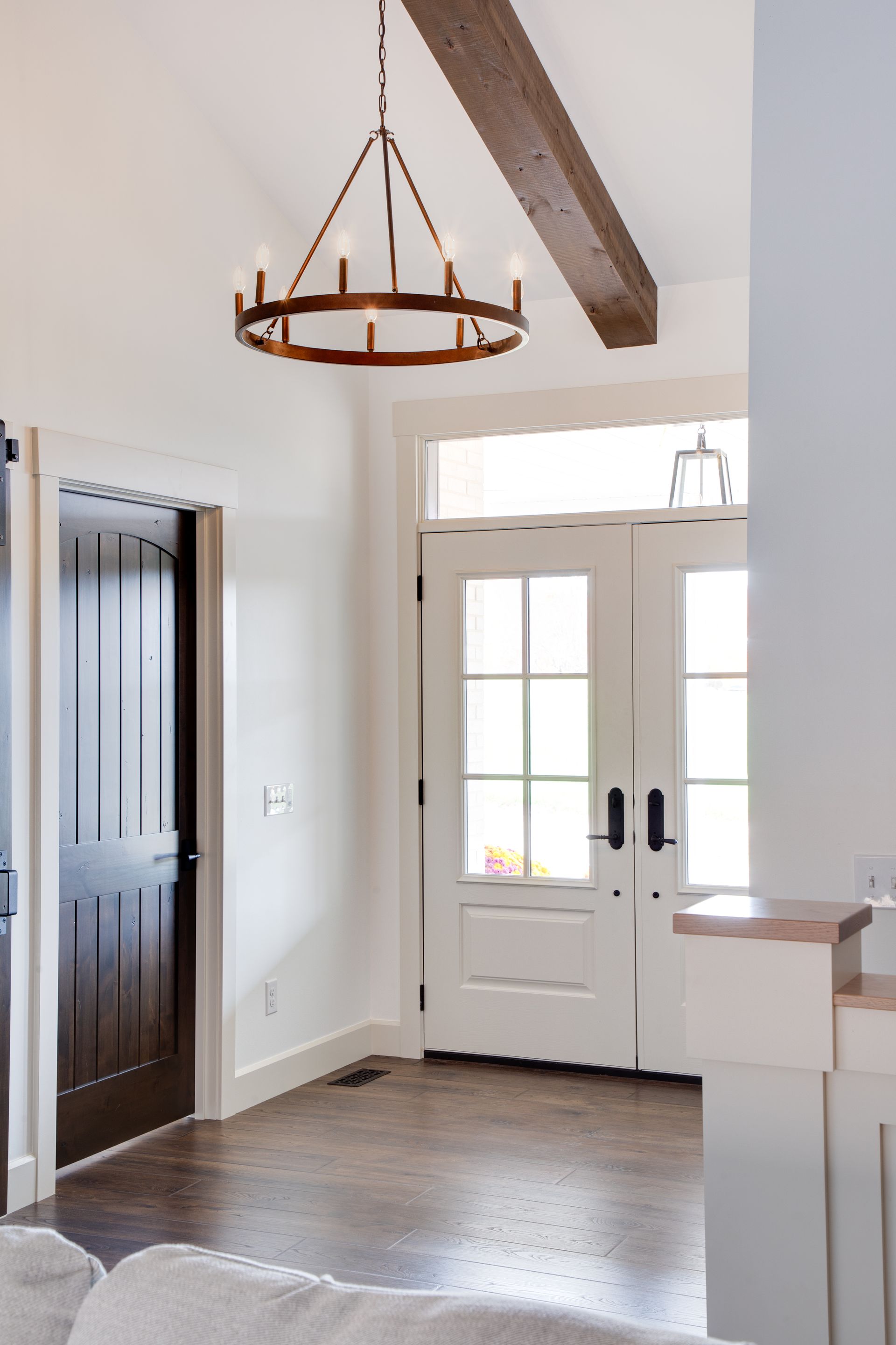 There is a chandelier hanging from the ceiling in the hallway.