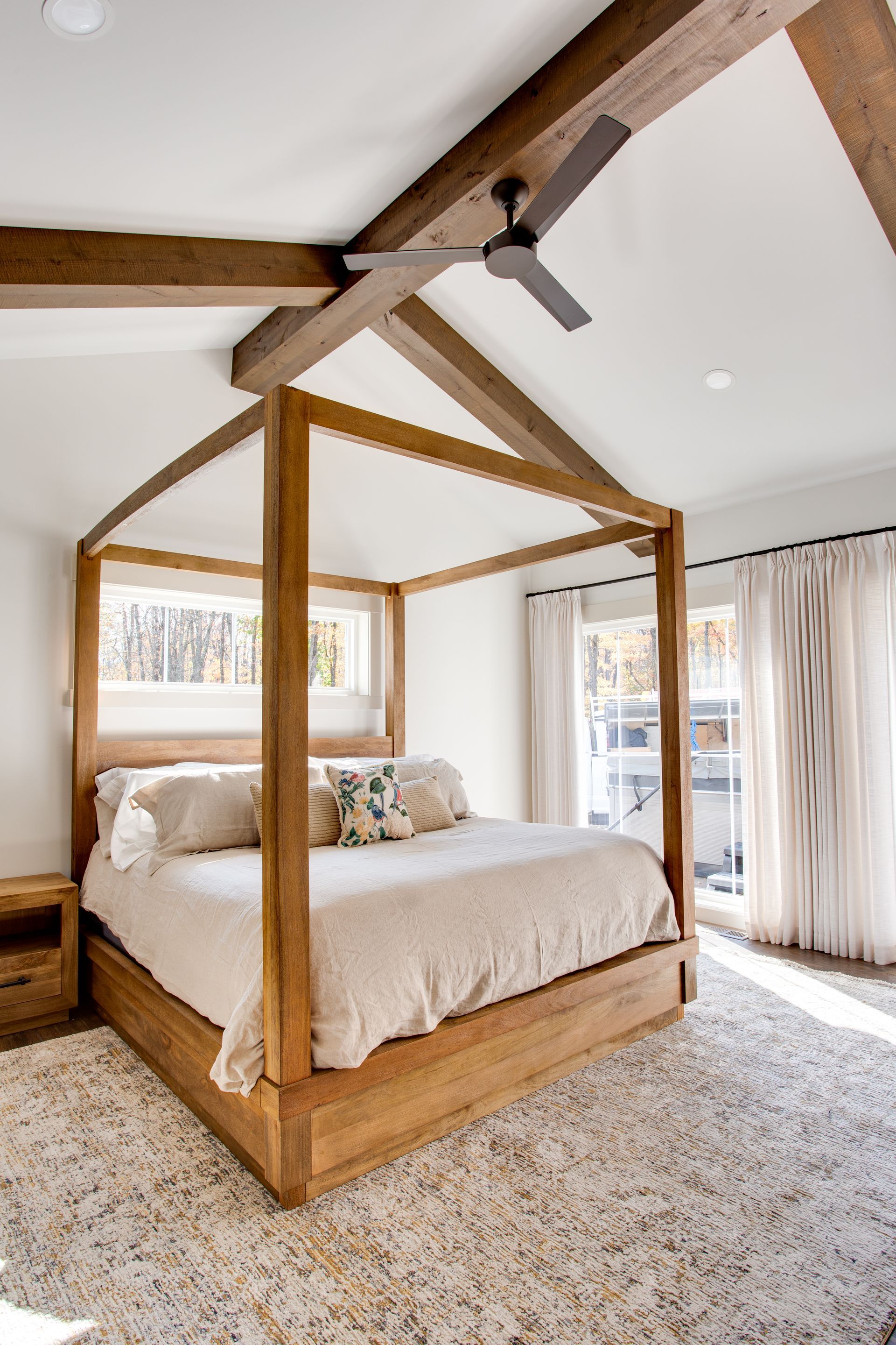 A bedroom with a canopy bed and a ceiling fan.