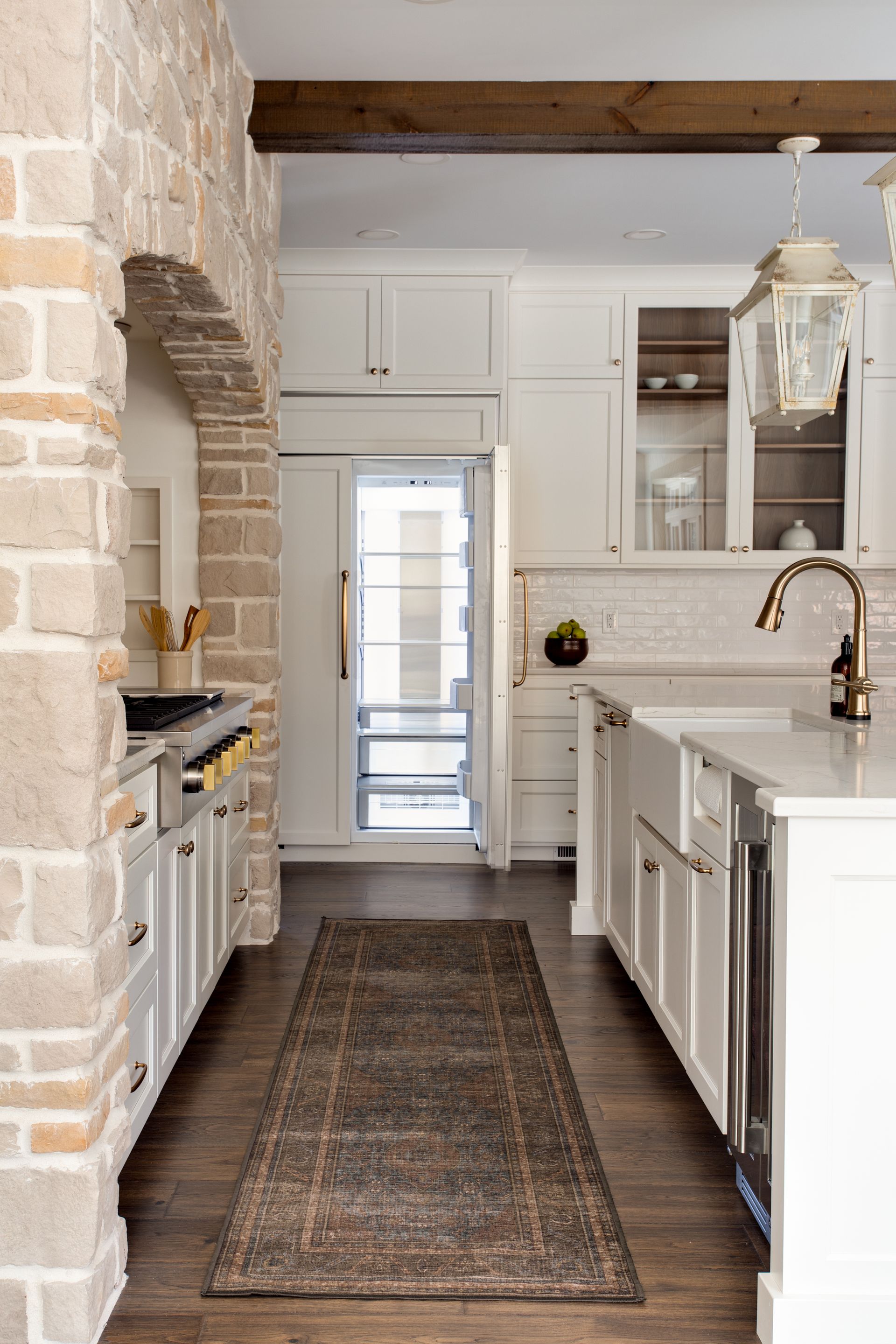A kitchen with white cabinets and a rug on the floor.