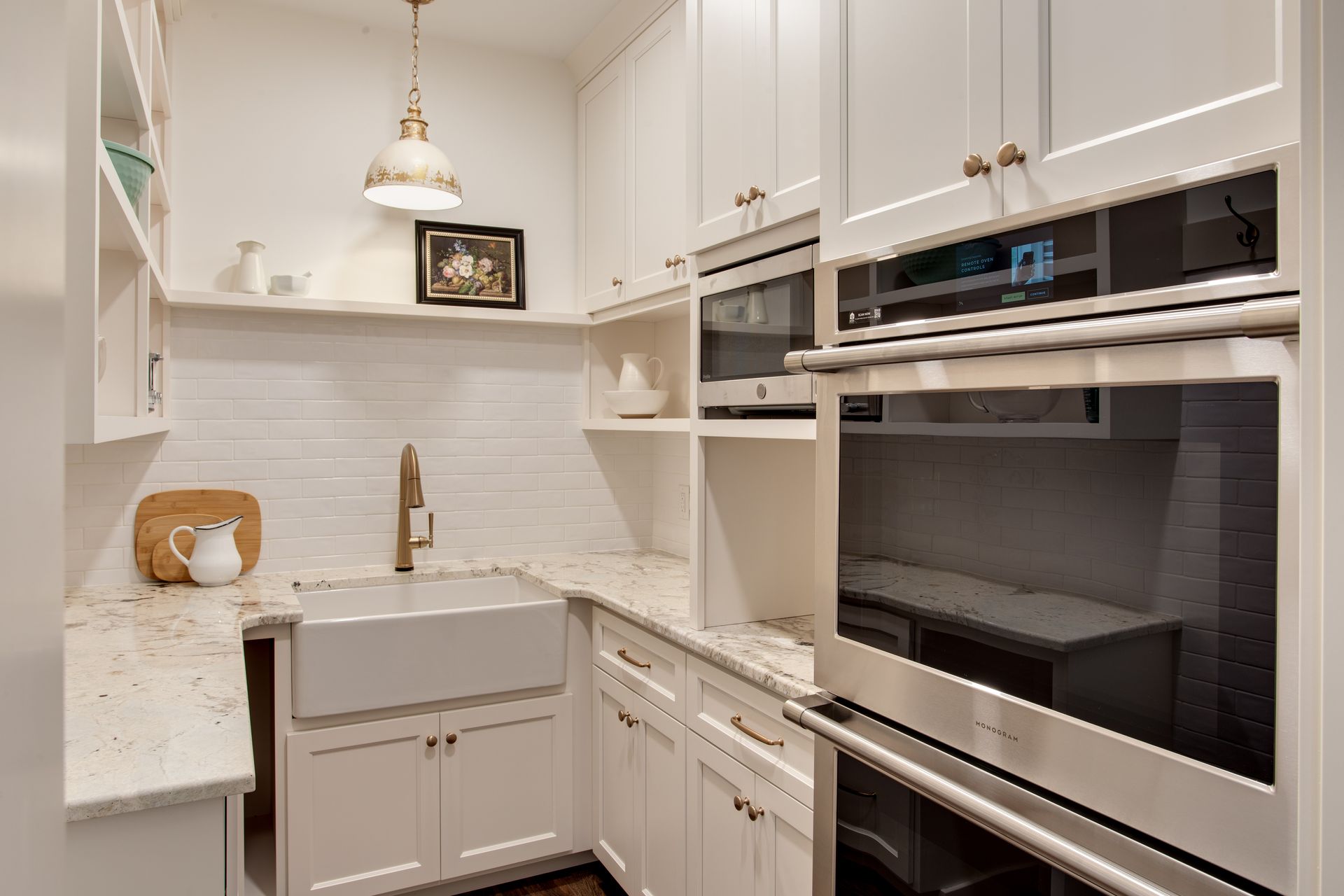 A kitchen with white cabinets , stainless steel appliances and a sink.