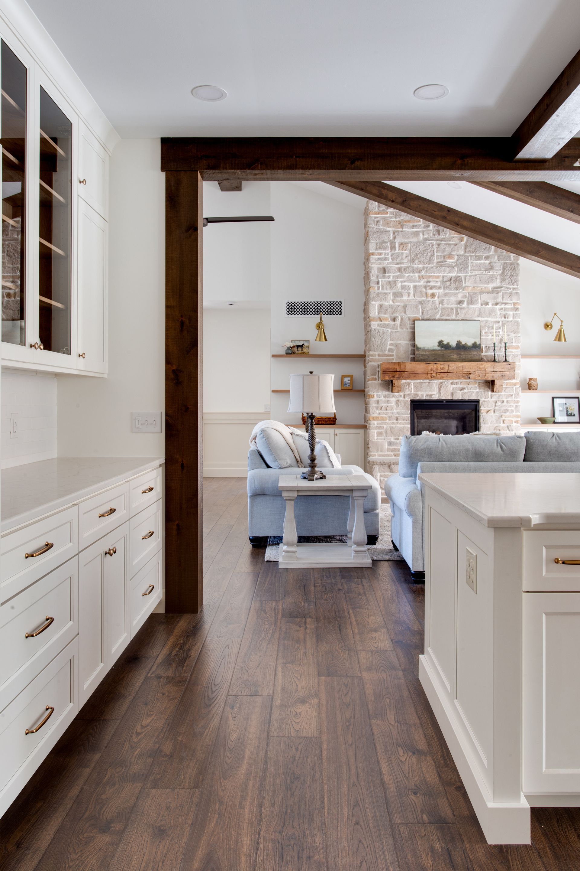 A kitchen leading to a living room with a fireplace and a couch.